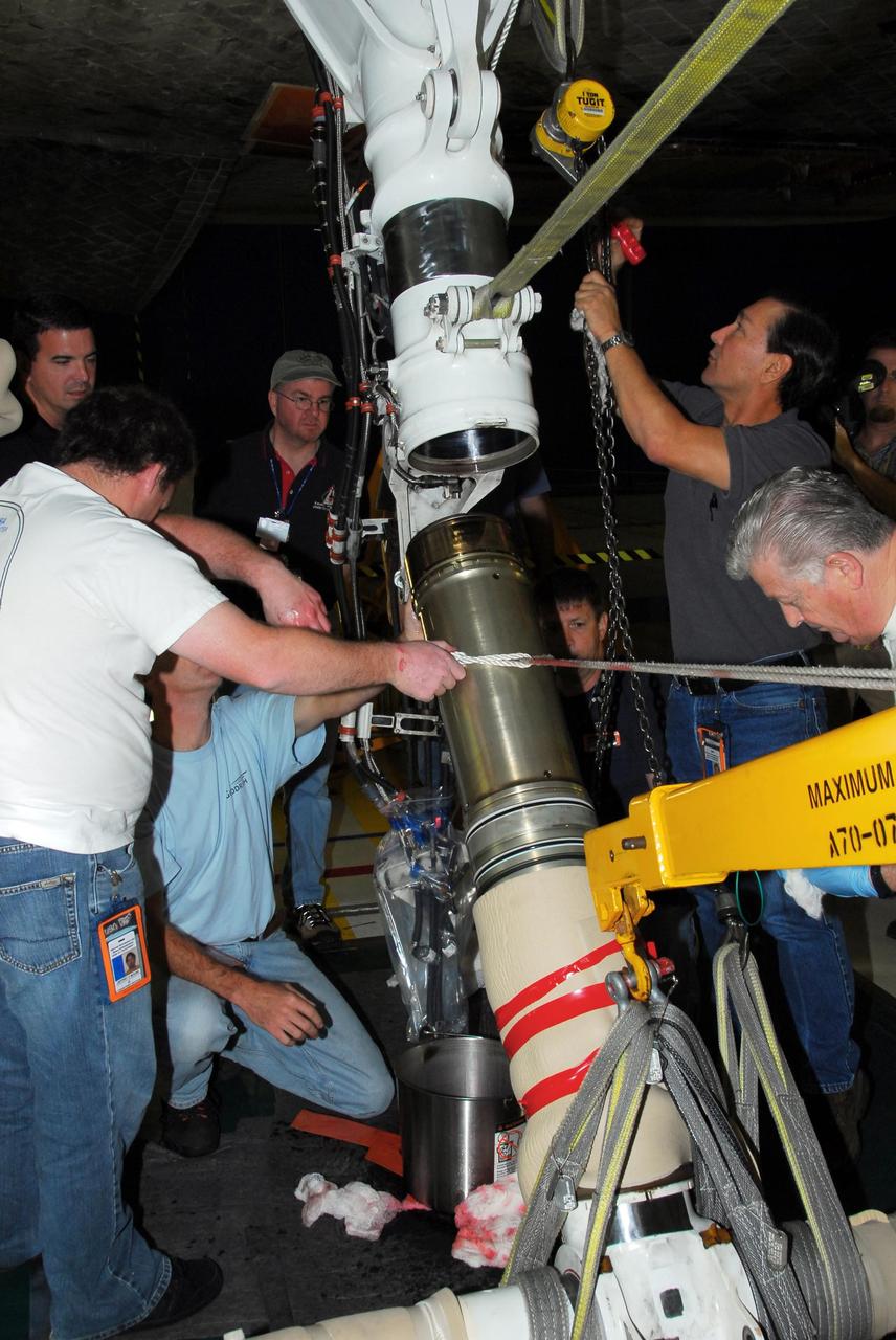 KENNEDY SPACE CENTER, FLA. -- In Orbiter Processing Facility bay 3, United Space Alliance and B.F. Goodrich technicians work on the starboard landing gear assembly of space shuttle Discovery.  They will replace a leaking dynamic seal in Discovery's right main-gear strut. The struts act as shock absorbers during the shuttle's landing.  Engineers determined the observed leak of hydraulic fluid in the main landing gear strut exceeded specification and could not be reduced to an acceptable rate. Removing the strut and replacing seals require disconnecting and replacing the brakes and tires, disconnecting and reconnecting instruments and other requirements to allow access to the strut.  Discovery had been scheduled to roll over Sept. 19 from its processing hangar to the Vehicle Assembly Building. A new rollover date will be set after technicians determine how long replacing the seal will take.  Photo credit: NASA/George Shelton