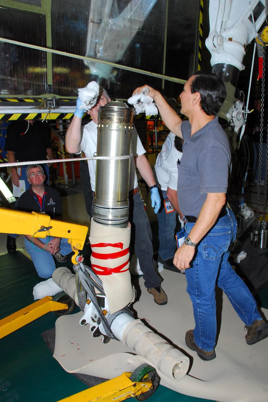 KENNEDY SPACE CENTER, FLA. -- In Orbiter Processing Facility bay 3, United Space Alliance and B.F. Goodrich technicians work on the starboard landing gear assembly of space shuttle Discovery.  They will replace a leaking dynamic seal in Discovery's right main-gear strut.  The struts act as shock absorbers during the shuttle's landing.  Engineers determined the observed leak of hydraulic fluid in the main landing gear strut exceeded specification and could not be reduced to an acceptable rate. Removing the strut and replacing seals require disconnecting and replacing the brakes and tires, disconnecting and reconnecting instruments and other requirements to allow access to the strut.  Discovery had been scheduled to roll over Sept. 19 from its processing hangar to the Vehicle Assembly Building. A new rollover date will be set after technicians determine how long replacing the seal will take.  Photo credit: NASA/George Shelton
