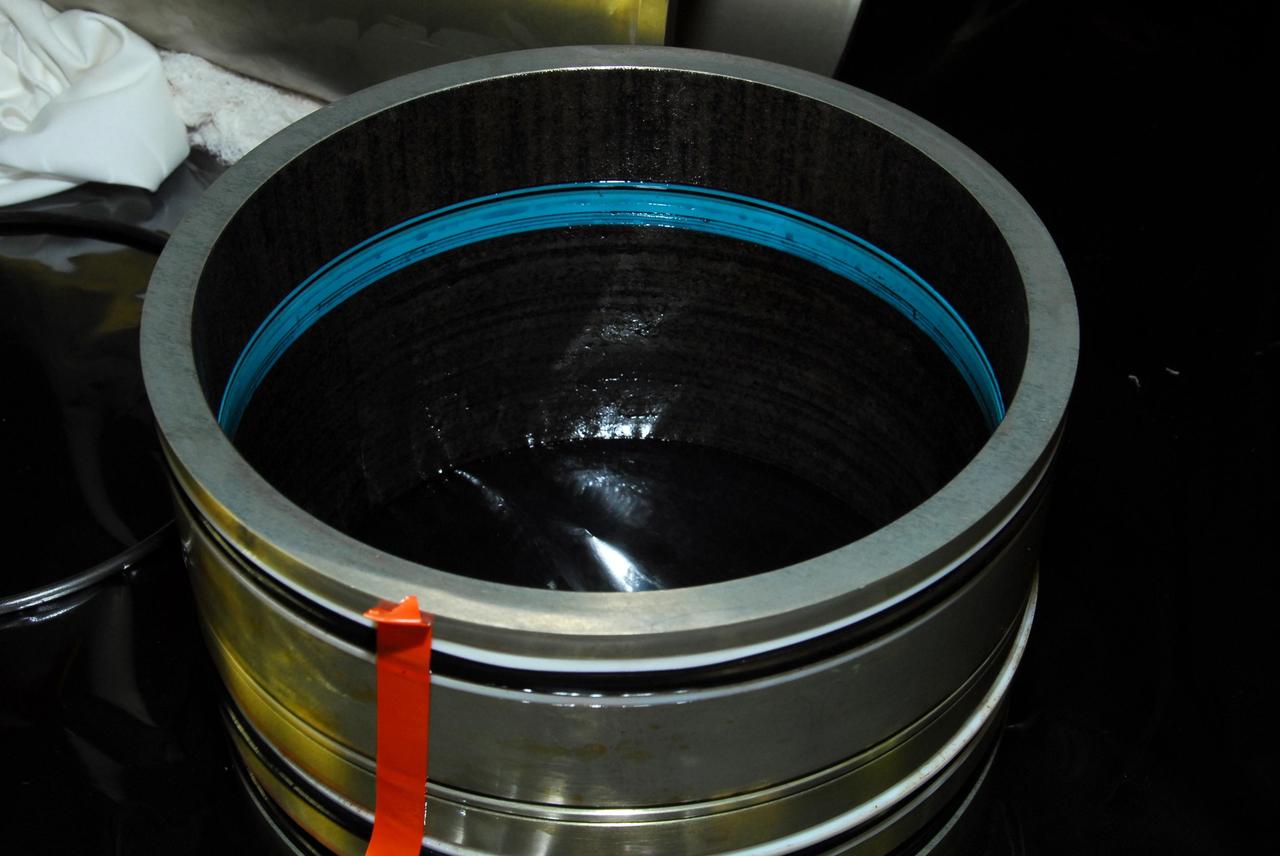 KENNEDY SPACE CENTER, FLA. -- This photo looks inside space shuttle Discovery's right main-gear strut where a leaking seal has been found.  United Space Alliance and B.F. Goodrich technicians will replace the seal.  The struts act as shock absorbers during the shuttle's landing.  Engineers determined the observed leak of hydraulic fluid in the main landing gear strut exceeded specification and could not be reduced to an acceptable rate. Removing the strut and replacing seals require disconnecting and replacing the brakes and tires, disconnecting and reconnecting instruments and other requirements to allow access to the strut.  Discovery had been scheduled to roll over Sept. 19 from its processing hangar to the Vehicle Assembly Building. A new rollover date will be set after technicians determine how long replacing the seal will take.  Photo credit: NASA/George Shelton