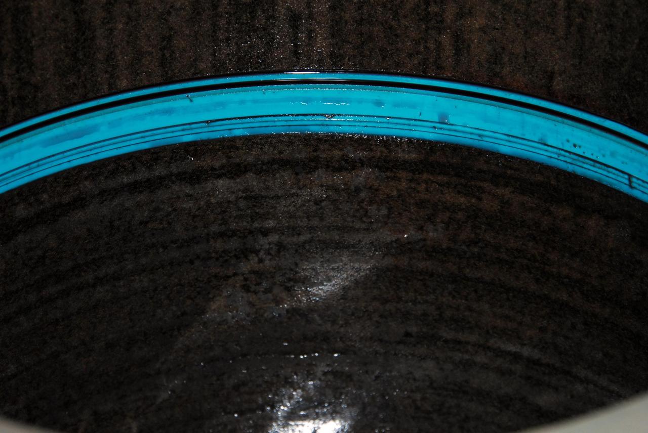 KENNEDY SPACE CENTER, FLA. -- This photo reveals the area of a seal on space shuttle Discovery's right main-gear strut that was determined to be leaking. United Space Alliance and B.F. Goodrich technicians are replacing the seal.  The struts act as shock absorbers during the shuttle's landing.  Engineers determined the observed leak of hydraulic fluid in the main landing gear strut exceeded specification and could not be reduced to an acceptable rate. Removing the strut and replacing seals require disconnecting and replacing the brakes and tires, disconnecting and reconnecting instruments and other requirements to allow access to the strut.  Discovery had been scheduled to roll over Sept. 19 from its processing hangar to the Vehicle Assembly Building. A new rollover date will be set after technicians determine how long replacing the seal will take.  Photo credit: NASA/George Shelton