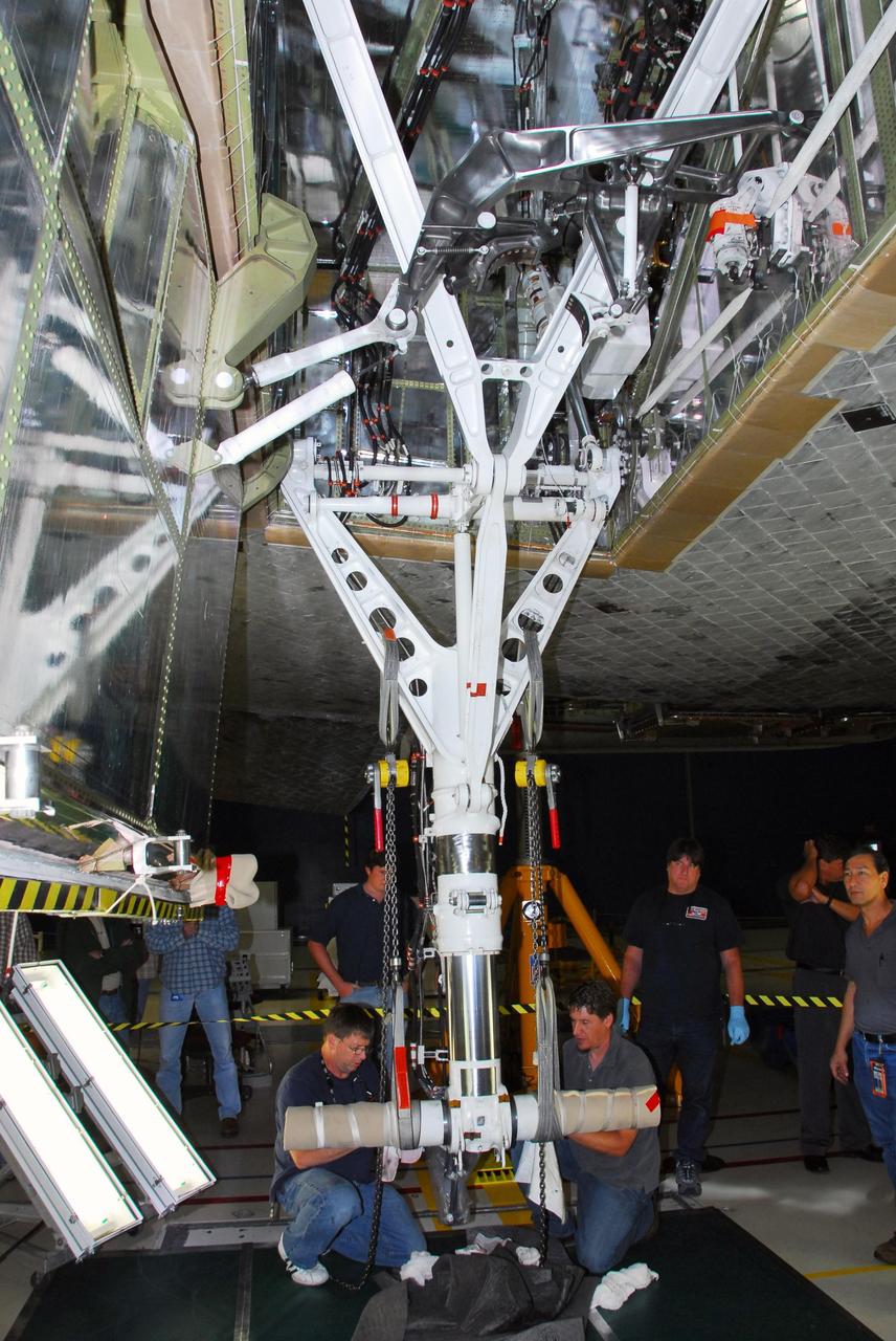 KENNEDY SPACE CENTER, FLA. -- In bay 3 of the Orbiter Processing Facility, United Space Alliance technicians make final adjustments on space shuttle Discovery's starboard landing gear.  The components were removed in order to replace a hydraulic seal in the right main-gear strut.  Engineers determined an observed leak of hydraulic fluid in the main landing gear strut exceeded specification and could not be reduced to an acceptable rate. Thus, the leaky seal and three other seals were replaced.  Prior to discovery of the leak, the vehicle had been scheduled to roll over Sept. 19 from the OPF to the Vehicle Assembly Building. A new rollover date will be set for Discovery, which is targeted for launch on Oct. 23.  Photo credit: NASA/George Shelton