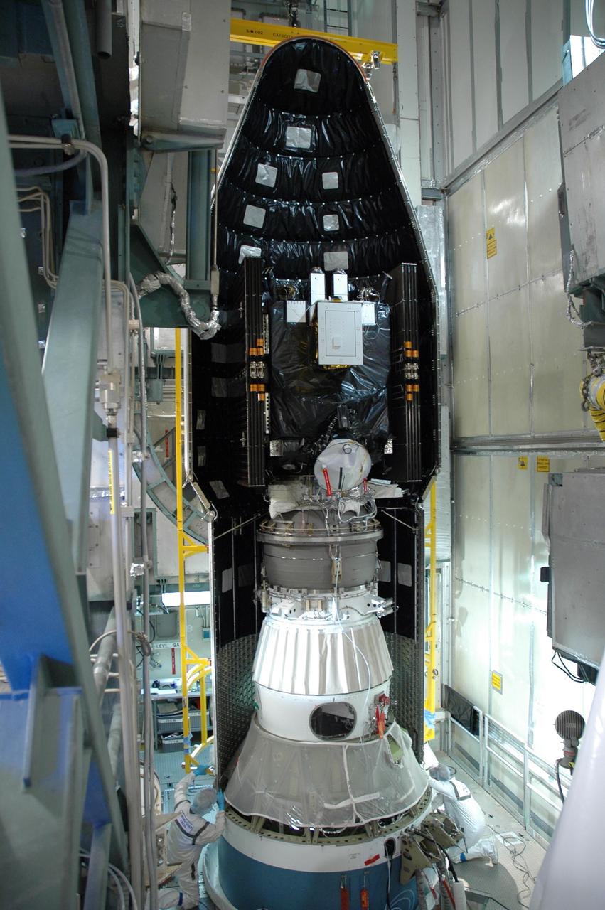 KENNEDY SPACE CENTER, FLA. --   Inside the mobile service tower on Launch Pad 17-B at Cape Canaveral Air Force Station, the first half of the fairing is moved into place around the Dawn spacecraft for installation. The fairing is a molded structure that fits flush with the outside surface of the Delta II upper stage booster and forms an aerodynamically smooth nose cone, protecting the spacecraft during launch and ascent.   Dawn is scheduled to launch between 7:25 and 7:54 a.m. on Sept. 26 aboard a Delta II rocket.  Photo credit: NASA/Jim Grossmann