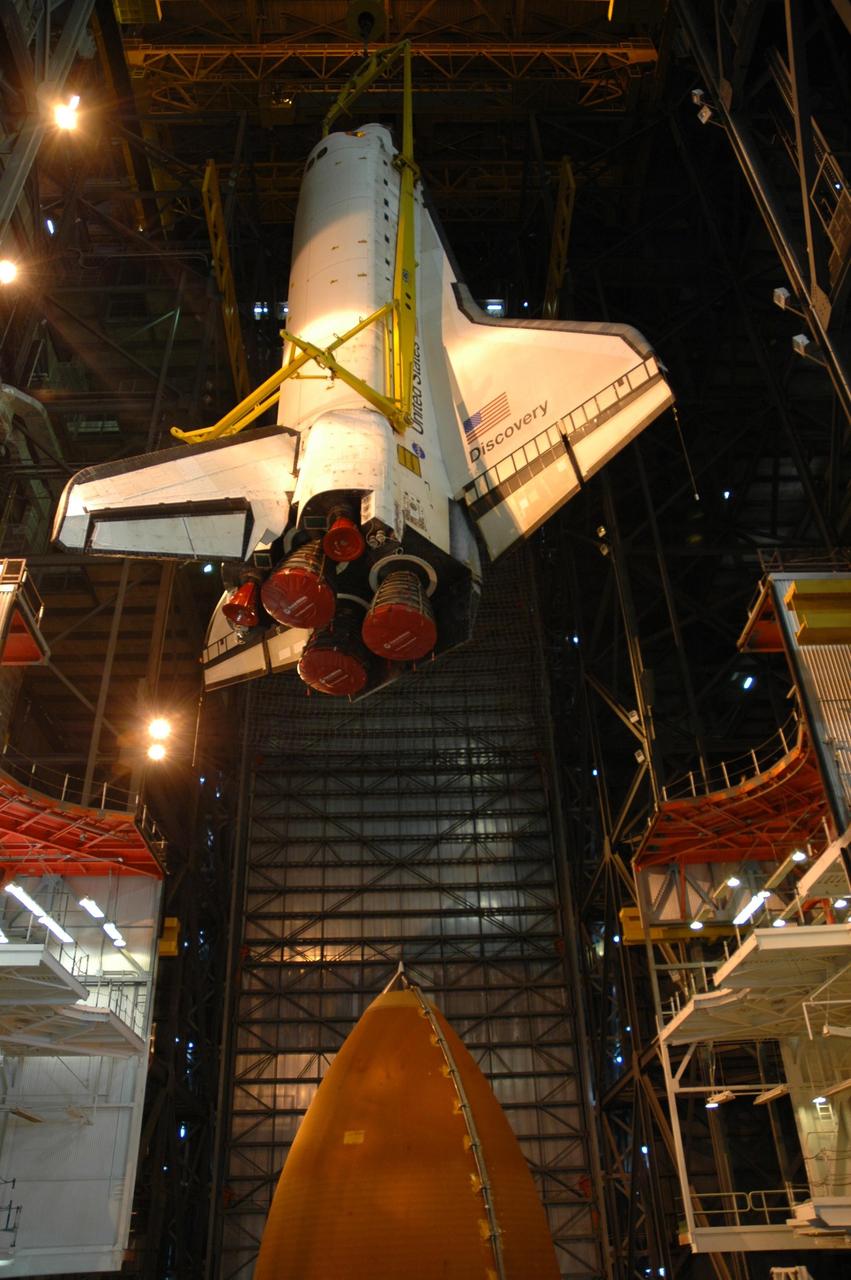 KENNEDY SPACE CENTER, FLA. -- Inside the Vehicle Assembly Building, space shuttle Discovery is lowered into high bay 1. Below it is the external tank. Discovery will be mated with the external tank and solid rocket boosters waiting on the mobile launcher platform. Discovery is targeted for launch to the International Space Station for mission STS-120 on Oct. 23. The crew will be delivering and installing the Italian-built U.S. Node 2, named Harmony. The pressurized module will act as an internal connecting port and passageway to additional international science labs and cargo spacecraft. In addition to increasing the living and working space inside the station, it also will serve as a work platform outside for the station's robotic arm. Photo credit: NASA/Troy Cryder