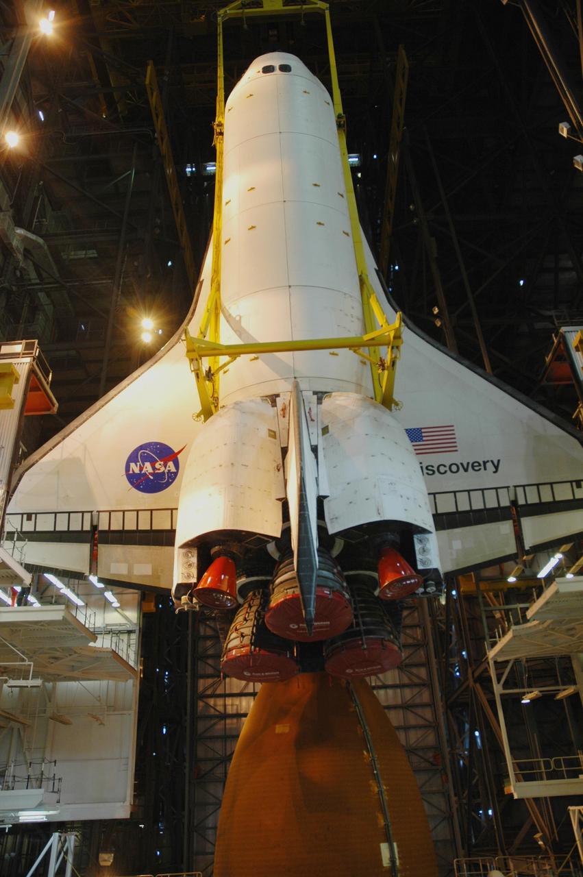 KENNEDY SPACE CENTER, FLA. -- Inside the Vehicle Assembly Building, space shuttle Discovery is lowered closer to the external tank in high bay 1. Discovery will be mated with the external tank and solid rocket boosters waiting on the mobile launcher platform. Discovery is targeted for launch to the International Space Station for mission STS-120 on Oct. 23. The crew will be delivering and installing the Italian-built U.S. Node 2, named Harmony. The pressurized module will act as an internal connecting port and passageway to additional international science labs and cargo spacecraft. In addition to increasing the living and working space inside the station, it also will serve as a work platform outside for the station's robotic arm. Photo credit: NASA/Troy Cryder
