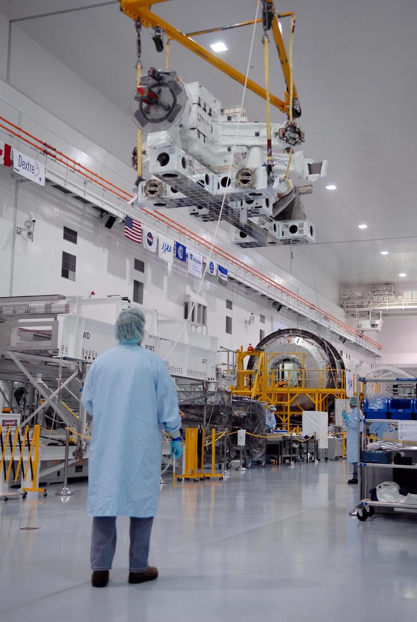KENNEDY SPACE CENTER, FLA. -- In the Space Station Processing Facility at NASA's Kennedy Space Center, technicians monitor the Special Purpose Dexterous Manipulator, known as Dextre, as a crane moves it into position onto a pallet.  Processing of the payload is under way for its mission to the International Space Station. Dextre will work with the mobile base and Canadarm2 on the station to perform critical construction and maintenance tasks. Dextre is part of the payload scheduled on mission STS-123, targeted to launch Feb. 14, 2008.  Photo credit: NASA/Kim Shiflett