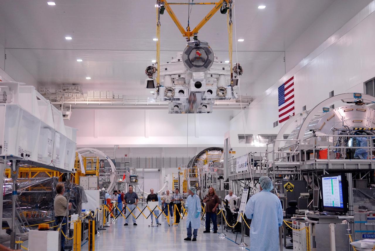 KENNEDY SPACE CENTER, FLA. -- In the Space Station Processing Facility at NASA's Kennedy Space Center, a crane lifts the Special Purpose Dexterous Manipulator, known as Dextre, high above the heads of the workers below to a position on a pallet. Processing of the payload is under way for its mission to the International Space Station. Dextre will work with the mobile base and Canadarm2 on the station to perform critical construction and maintenance tasks. Dextre is part of the payload scheduled on mission STS-123, targeted to launch Feb. 14, 2008.  Photo credit: NASA/Kim Shiflett