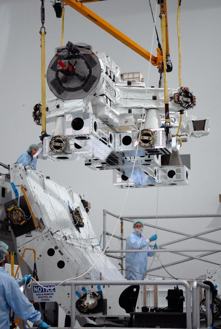 KENNEDY SPACE CENTER, FLA. -- In the Space Station Processing Facility at NASA's Kennedy Space Center, technicians guide the Special Purpose Dexterous Manipulator, known as Dextre, as a crane lowers it toward a pallet.  Processing of the payload is under way for its mission to the International Space Station. Dextre will work with the mobile base and Canadarm2 on the station to perform critical construction and maintenance tasks. Dextre is part of the payload scheduled on mission STS-123, targeted to launch Feb. 14, 2008.  Photo credit: NASA/Kim Shiflett