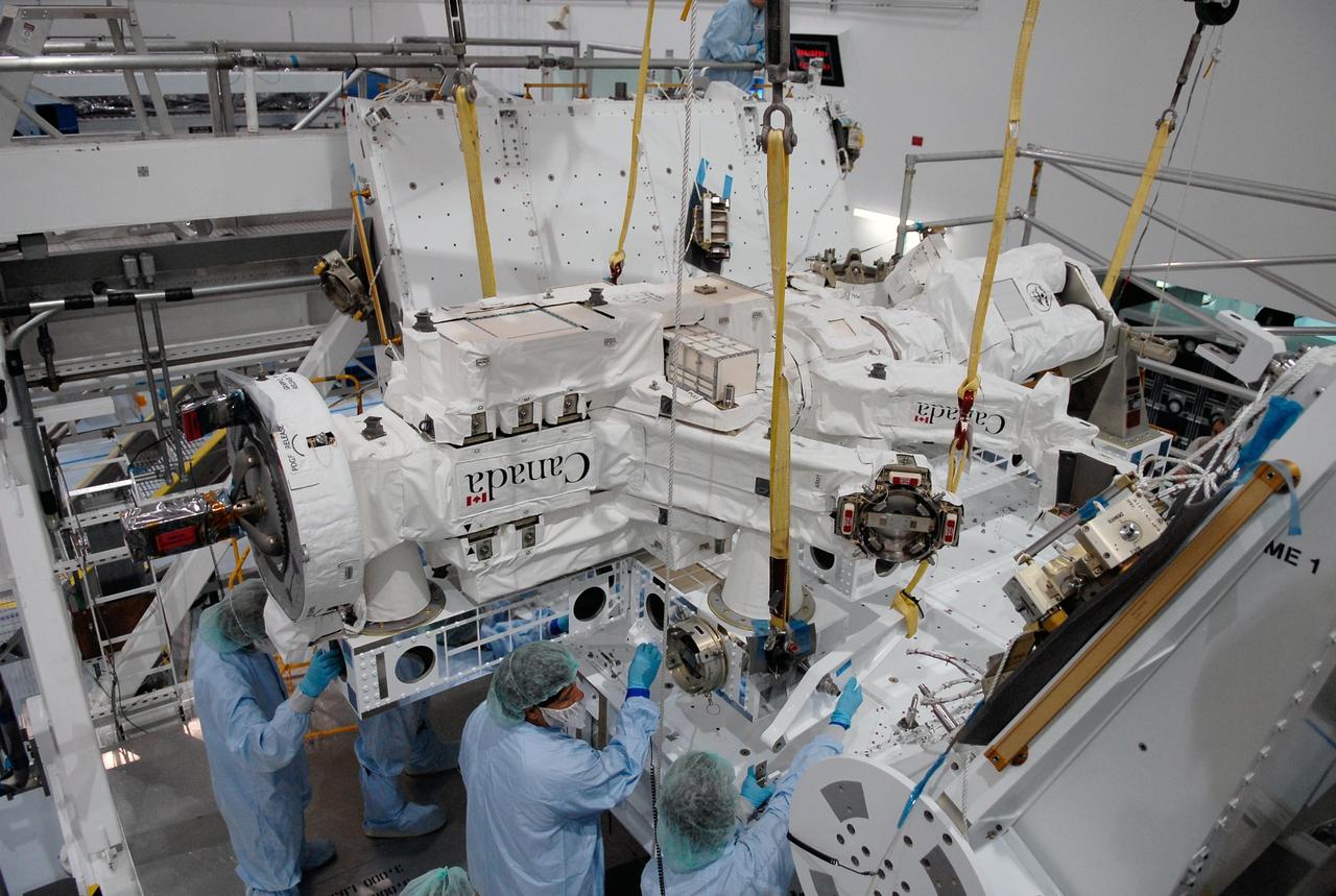 KENNEDY SPACE CENTER, FLA. -- In the Space Station Processing Facility at NASA's Kennedy Space Center, technicians adjust the Special Purpose Dexterous Manipulator, known as Dextre, into position on a pallet.  Processing of the payload is under way for its mission to the International Space Station. Dextre will work with the mobile base and Canadarm2 on the station to perform critical construction and maintenance tasks. Dextre is part of the payload scheduled on mission STS-123, targeted to launch Feb. 14, 2008.  Photo credit: NASA/Kim Shiflett