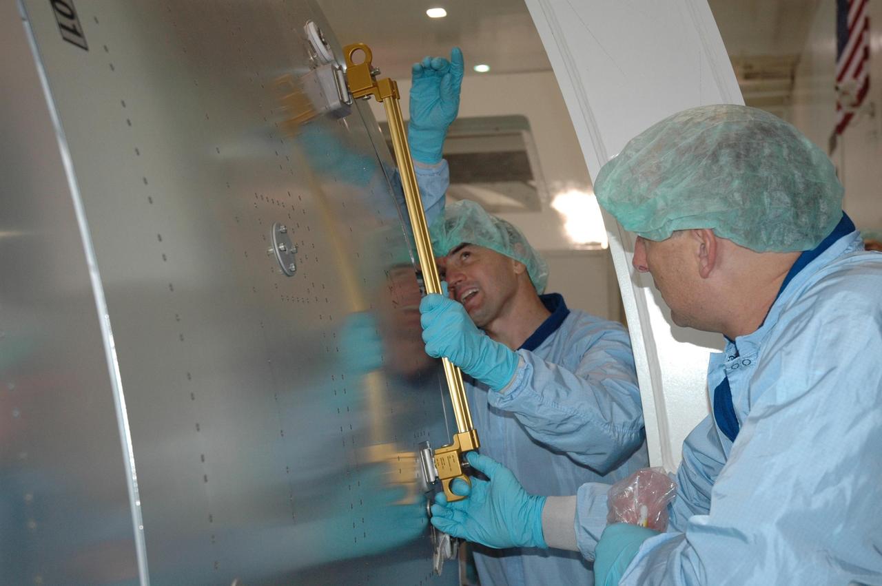 KENNEDY SPACE CENTER, FLA. -- STS-122 Mission Specialist Rex Walheim points at part of the Columbus Research Laboratory in the Space Station Processing Facility. He and other crew members are at Kennedy to take part in a crew equipment interface test, which helps familiarize them with equipment and payloads for the mission. Among the activities standard to a CEIT are harness training, inspection of the thermal protection system and camera operation for planned extravehicular activities, or EVAs. The crew comprises Commander Stephen Frick, Pilot Alan Poindexter, and Mission Specialists Rex Walheim, Stanley Love, Leland Melvin and Hans Schlegel, who represents the European Space Agency. The Columbus Lab is Europe’s largest contribution to the construction of the International Space Station. It will support scientific and technological research in a microgravity environment. Columbus, a program of ESA, is a multifunctional, pressurized laboratory that will be permanently attached to Node 2 of the space station to carry out experiments in materials science, fluid physics and biosciences, as well as to perform a number of technological applications. STS-122 is targeted for launch in December. Photo credit: NASA/Jim Grossmann