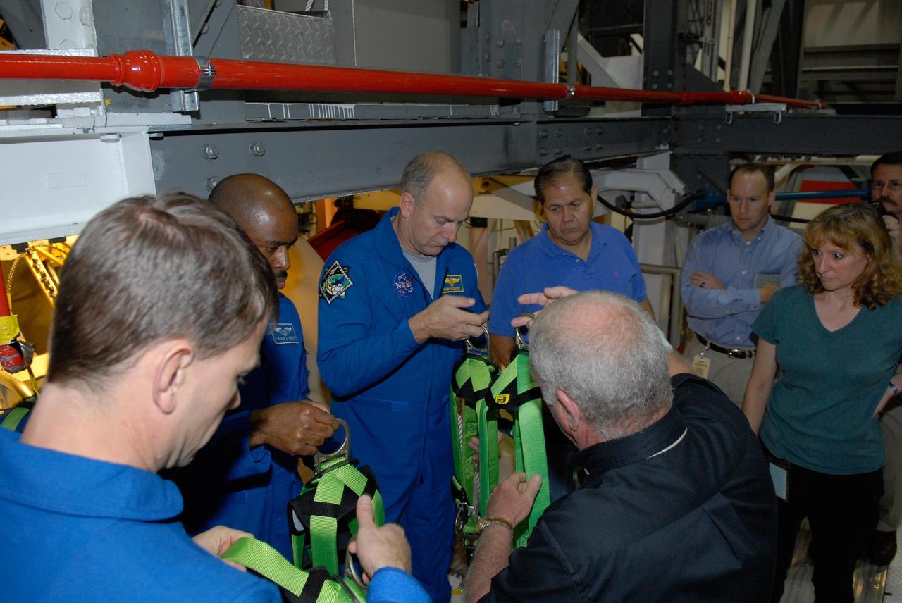 KENNEDY SPACE CENTER, FLA. --  Members of the STS-122 crew take part in harness training in the Orbiter Processing Facility at NASA's Kennedy Space Center.  Seen from left are Mission Specialists Stanley Love and Leland Melvin and Pilot Alan Poindexter. The crew is at Kennedy to take part in a crew equipment interface test, or CEIT, which helps familiarize them with equipment and payloads for the mission.  Among the activities standard to a CEIT are harness training, inspection of the thermal protection system and camera operation for planned extravehicular activities, or EVAs.  STS-122 is targeted for launch in December.   Photo credit: NASA/Kim Shiflett