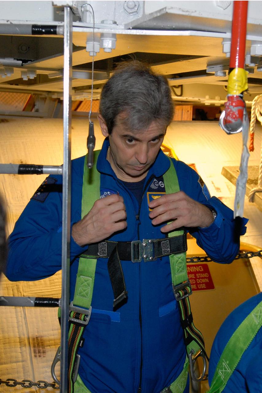 KENNEDY SPACE CENTER, FLA. -- Astronaut Leopold Eyharts, who represents the European Space Agency, tries on a harness in the Orbiter Processing Facility.  Eyharts will be traveling to the International Space Station to join the Expedition 16 crew as a flight engineer. The crew is at Kennedy to take part in a crew equipment interface test, or CEIT, which helps familiarize them with equipment and payloads for the mission.  Among the activities standard to a CEIT are harness training, inspection of the thermal protection system and camera operation for planned extravehicular activities, or EVAs.  STS-122 is targeted for launch in December.   Photo credit: NASA/Kim Shiflett