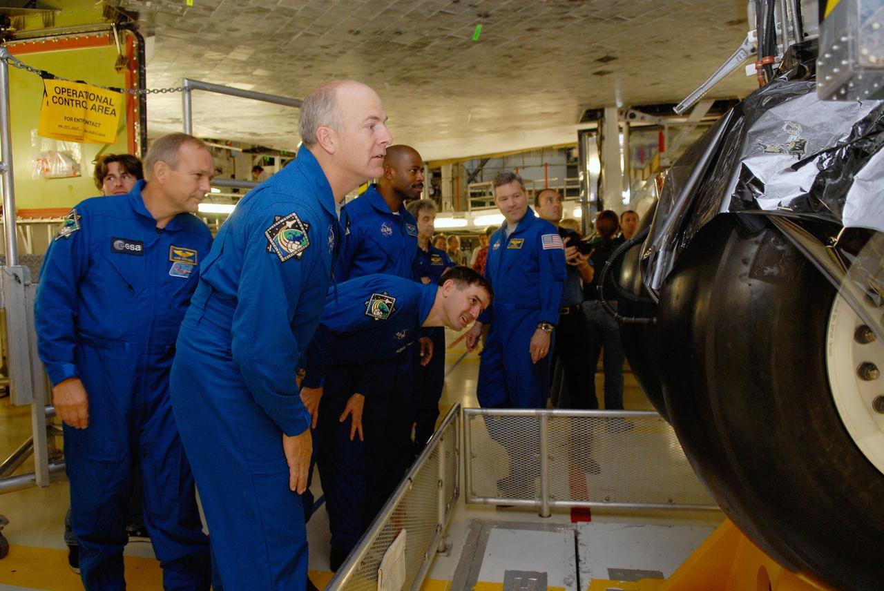 KENNEDY SPACE CENTER, FLA. -- In the Orbiter Processing Facility, members of the STS-122 crew get a close look at the landing gear on space shuttle Atlantis.  From left are Mission Specialist Hans Schlegel, Pilot Alan Poindexter, Mission Specialists Rex Walheim and Leland Melvin and Commander Stephen Frick.  Schlegel represents the European Space Agency.  The crew is at Kennedy to take part in a crew equipment interface test, or CEIT, which helps familiarize them with equipment and payloads for the mission.  Among the activities standard to a CEIT are harness training, inspection of the thermal protection system and camera operation for planned extravehicular activities, or EVAs.  STS-122 is targeted for launch in December.   Photo credit: NASA/Kim Shiflett