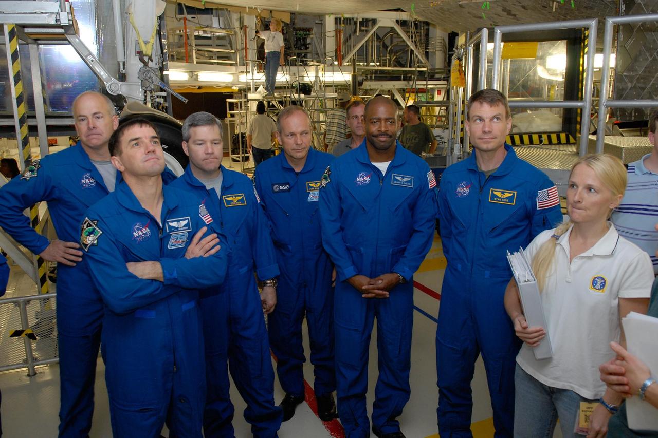 KENNEDY SPACE CENTER, FLA. -- In the Orbiter Processing Facility, members of the STS-122 crew get information about the thermal protection system on space shuttle Atlantis (overhead).  From left are Pilot Alan Poindexter, Mission Specialists Rex Walheim, Commander Stephen Frick, and Mission Specialists Hans Schlegel, Leland Melvin and Stanley Love. Schlegel represents the European Space Agency. The crew is at Kennedy to take part in a crew equipment interface test, or CEIT, which helps familiarize them with equipment and payloads for the mission.  Among the activities standard to a CEIT are harness training, inspection of the thermal protection system and camera operation for planned extravehicular activities, or EVAs.  STS-122 is targeted for launch in December.   Photo credit: NASA/Kim Shiflett