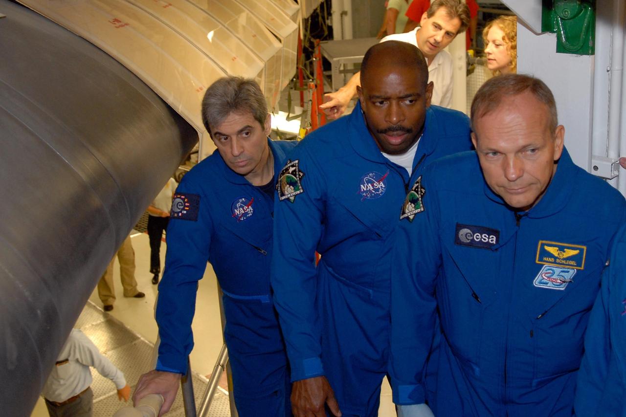KENNEDY SPACE CENTER, FLA. -- In the Orbiter Processing Facility, STS-122 crew members stand next to the space shuttle Atlantis, which is being processed for launch on STS-122.  From left are European Space Agency astronaut Leopold Eyharts and Mission Specialists Leland Melvin and Hans Schlegel, who also represents ESA.  Eyharts will be traveling to the International Space Station to join the Expedition 16 crew as a flight engineer.  The crew is at Kennedy to take part in a crew equipment interface test, or CEIT, which helps familiarize them with equipment and payloads for the mission.  Among the activities standard to a CEIT are harness training, inspection of the thermal protection system and camera operation for planned extravehicular activities, or EVAs.  STS-122 is targeted for launch in December.   Photo credit: NASA/Kim Shiflett