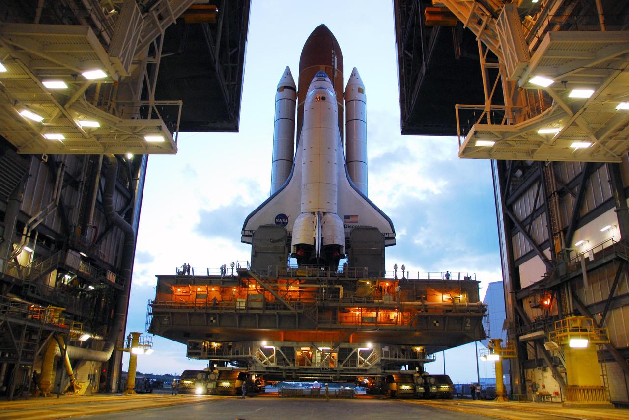 KENNEDY SPACE CENTER, FLA. -- Space Shuttle Discovery, atop a mobile launch platform, moves through the doors of the Vehicle Assembly Building toward Launch Pad 39A just before sunrise on a balmy Florida morning. First motion out of the VAB was at 6:47 a.m. EDT.  Rollout is a milestone for Discovery's launch to the International Space Station on mission STS-120, targeted for Oct. 23. The crew will be delivering and installing the Italian-built U.S. Node 2, named Harmony. The pressurized module will act as an internal connecting port and passageway to additional international science labs and cargo spacecraft. In addition to increasing the living and working space inside the station, it also will serve as a work platform outside for the station's robotic arm.   Photo credit: NASA/George Shelton