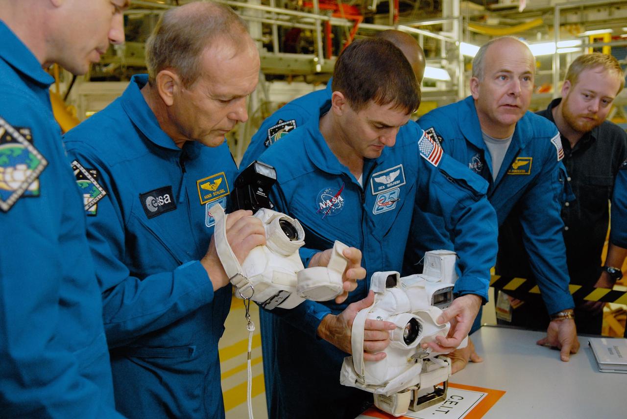 KENNEDY SPACE CENTER, FLA. --  In the Orbiter Processing Facility, members of the STS-122 crew look over cameras that will be used during the mission.  From left are Mission Specialists Stanley Love, Hans Schlegel and Rex Walheim and Pilot Alan Poindexter.  The crew is at Kennedy Space Center to take part in a crew equipment interface test, which helps familiarize them with equipment and payloads for the mission.  Among the activities standard to a CEIT are harness training, inspection of the thermal protection system and camera operation for planned extravehicular activities, or EVAs.  The mission will carry and install the Columbus Lab,  a multifunctional, pressurized laboratory that will be permanently attached to Node 2 of the space station to carry out experiments in materials science, fluid physics and biosciences, as well as to perform a number of technological applications. It is Europe’s largest contribution to the construction of the International Space Station and will support scientific and technological research in a microgravity environment.  STS-122 is targeted for launch in December.   Photo credit: NASA/Kim Shiflett
