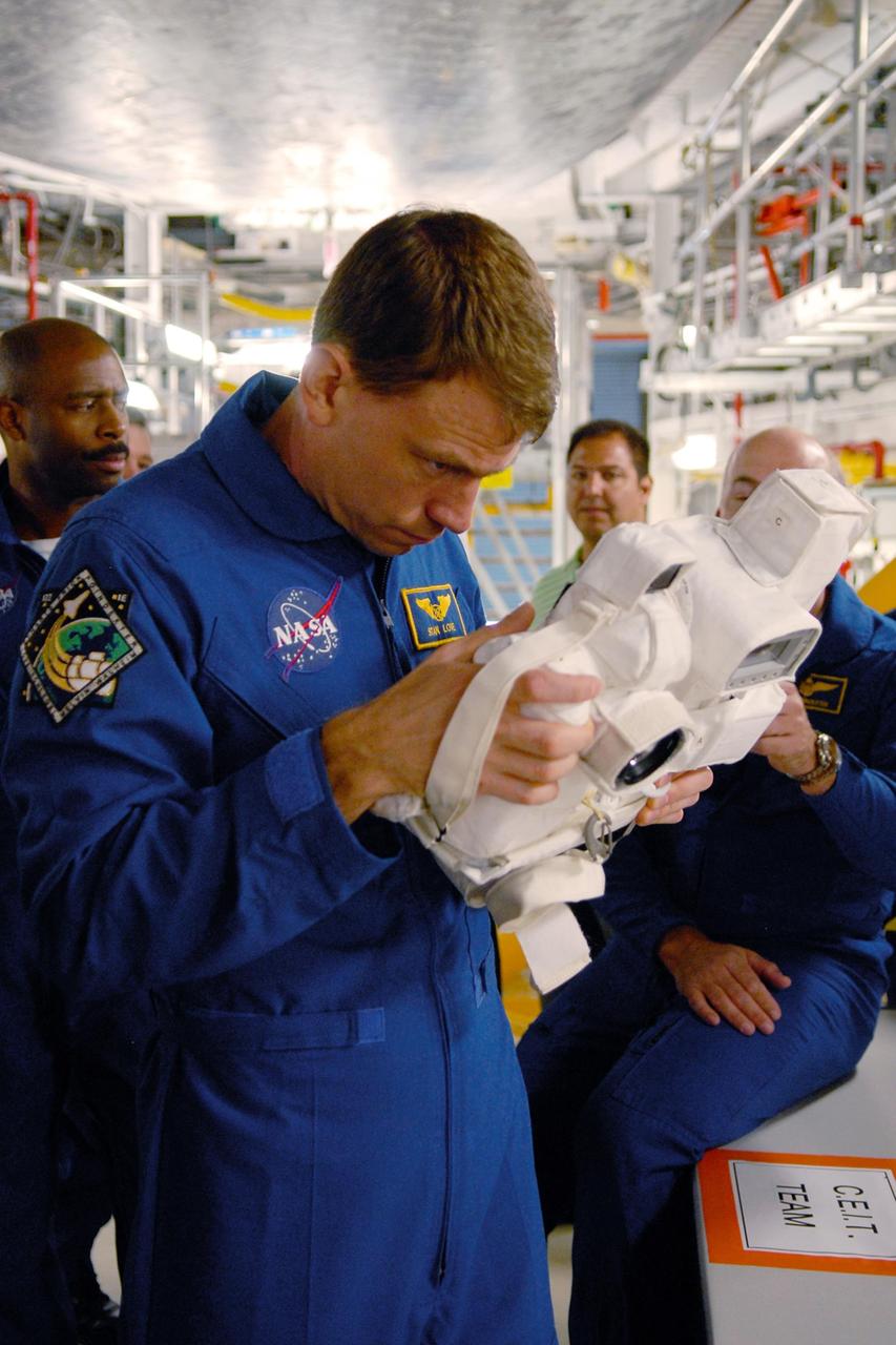 KENNEDY SPACE CENTER, FLA. --  In the Orbiter Processing Facility, members of the STS-122 crew practice handling cameras that will be used during the mission.  In the foreground is Mission Specialist Stanley Love.  Behind him at left is Mission Specialist Leland Melvin; at right is Pilot Alan Poindexter.  The crew is at Kennedy Space Center to take part in a crew equipment interface test, which helps familiarize them with equipment and payloads for the mission.  Among the activities standard to a CEIT are harness training, inspection of the thermal protection system and camera operation for planned extravehicular activities, or EVAs.  The mission will carry and install the Columbus Lab,  a multifunctional, pressurized laboratory that will be permanently attached to Node 2 of the space station to carry out experiments in materials science, fluid physics and biosciences, as well as to perform a number of technological applications. It is Europe’s largest contribution to the construction of the International Space Station and will support scientific and technological research in a microgravity environment.  STS-122 is targeted for launch in December.   Photo credit: NASA/Kim Shiflett