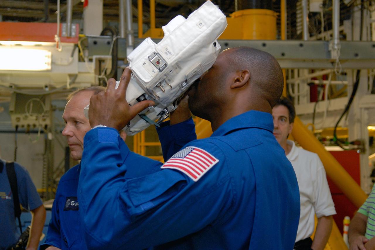 KENNEDY SPACE CENTER, FLA. --  In the Orbiter Processing Facility, members of the STS-122 crew practice handling cameras that will be used during the mission.  With the camera is Mission Specialist Leland Melvin.  At left is Mission Specialist Hans Schlegel, who represents the European Space Agency.  The crew is at Kennedy Space Center to take part in a crew equipment interface test, which helps familiarize them with equipment and payloads for the mission.  Among the activities standard to a CEIT are harness training, inspection of the thermal protection system and camera operation for planned extravehicular activities, or EVAs.  The mission will carry and install the Columbus Lab,  a multifunctional, pressurized laboratory that will be permanently attached to Node 2 of the space station to carry out experiments in materials science, fluid physics and biosciences, as well as to perform a number of technological applications. It is Europe’s largest contribution to the construction of the International Space Station and will support scientific and technological research in a microgravity environment.  STS-122 is targeted for launch in December.   Photo credit: NASA/Kim Shiflett