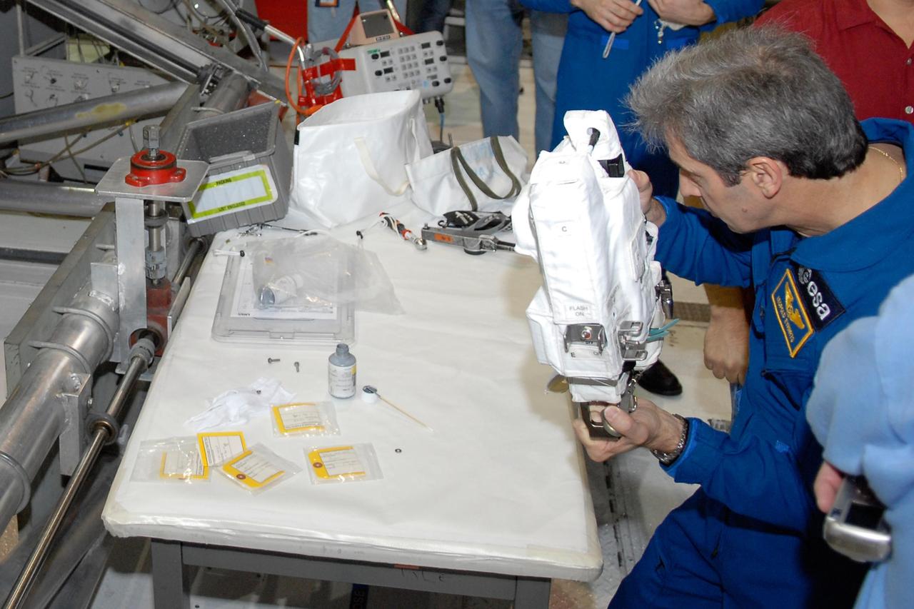 KENNEDY SPACE CENTER, FLA. -- In the Orbiter Processing Facility, members of the STS-122 crew practice handling cameras that will be used during the mission.  Holding the camera is astronaut Leopold Eyharts, with the European Space Agency.  He will be joining the Expedition 15 crew on the International Space Station.  The crew is at Kennedy Space Center to take part in a crew equipment interface test, which helps familiarize them with equipment and payloads for the mission.  Among the activities standard to a CEIT are harness training, inspection of the thermal protection system and camera operation for planned extravehicular activities, or EVAs.  The mission will carry and install the Columbus Lab,  a multifunctional, pressurized laboratory that will be permanently attached to Node 2 of the space station to carry out experiments in materials science, fluid physics and biosciences, as well as to perform a number of technological applications. It is Europe’s largest contribution to the construction of the International Space Station and will support scientific and technological research in a microgravity environment.  STS-122 is targeted for launch in December.   Photo credit: NASA/Kim Shiflett