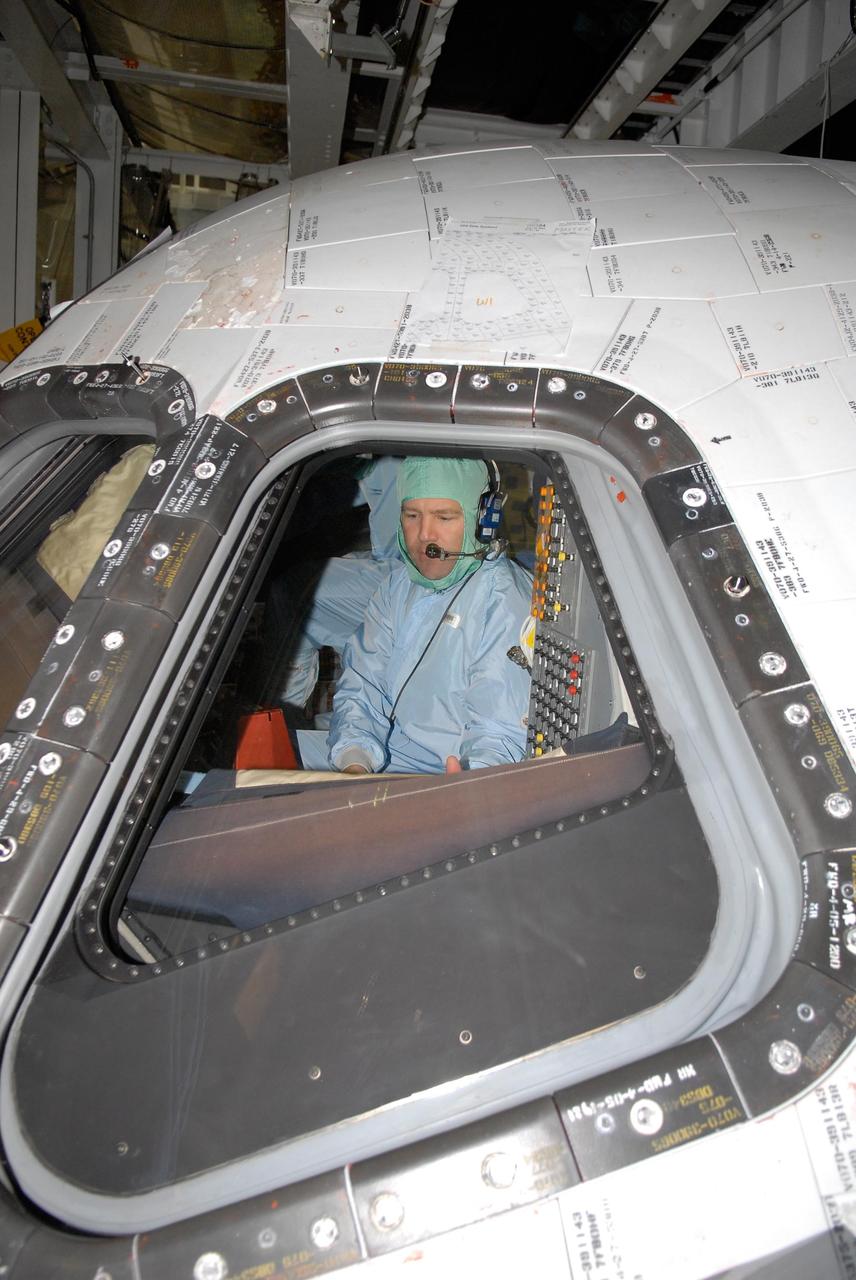 KENNEDY SPACE CENTER, FLA. -- In the Orbiter Processing Facility, STS-122 Commander Stephen Frick checks out the cockpit on space shuttle Atlantis.  He and other crew members are at Kennedy Space Center to take part in a crew equipment interface test, which helps familiarize them with equipment and payloads for the mission.  Among the activities standard to a CEIT are harness training, inspection of the thermal protection system and camera operation for planned extravehicular activities, or EVAs.  The mission will carry and install the Columbus Lab,  a multifunctional, pressurized laboratory that will be permanently attached to Node 2 of the space station to carry out experiments in materials science, fluid physics and biosciences, as well as to perform a number of technological applications. It is Europe’s largest contribution to the construction of the International Space Station and will support scientific and technological research in a microgravity environment.  STS-122 is targeted for launch in December.   Photo credit: NASA/Kim Shiflett