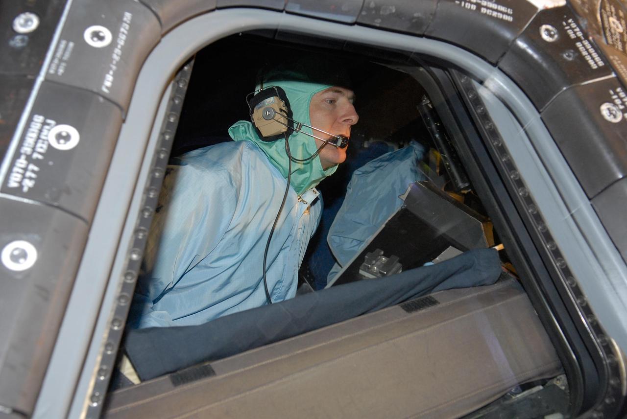 KENNEDY SPACE CENTER, FLA. -- In the Orbiter Processing Facility, STS-122 Pilot Alan Poindexter checks out the cockpit on space shuttle Atlantis. The crew is at Kennedy Space Center to take part in a crew equipment interface test, which helps familiarize them with equipment and payloads for the mission.  Among the activities standard to a CEIT are harness training, inspection of the thermal protection system and camera operation for planned extravehicular activities, or EVAs.  The mission will carry and install the Columbus Lab,  a multifunctional, pressurized laboratory that will be permanently attached to Node 2 of the space station to carry out experiments in materials science, fluid physics and biosciences, as well as to perform a number of technological applications. It is Europe’s largest contribution to the construction of the International Space Station and will support scientific and technological research in a microgravity environment.  STS-122 is targeted for launch in December.   Photo credit: NASA/Kim Shiflett