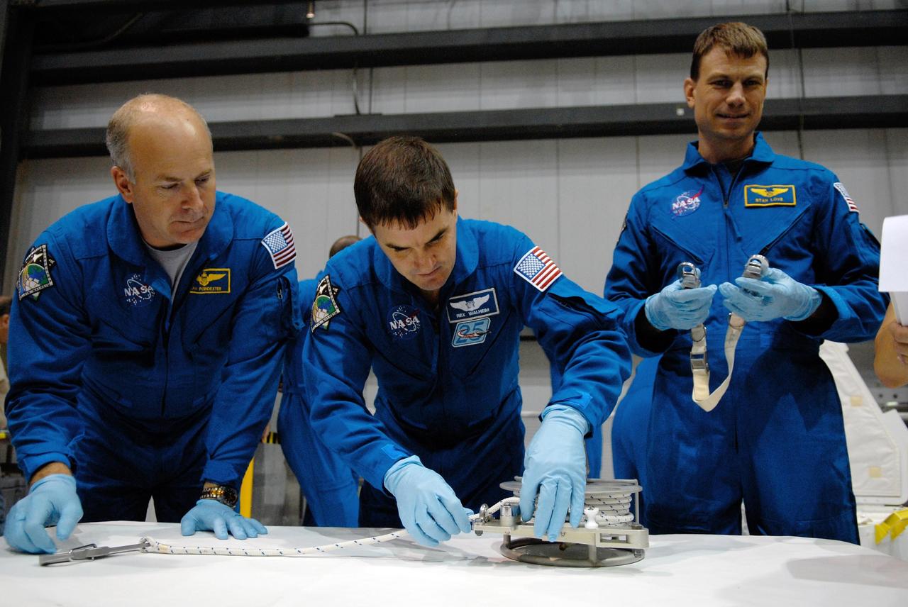 KENNEDY SPACE CENTER, FLA. -- In the Orbiter Processing Facility, STS-122 Pilot Alan Poindexter and Mission Specialists Rex Walheim and Stanley Love practice working with equipment for the mission.  The crew is at Kennedy Space Center to take part in a crew equipment interface test, which includes equipment familiarization.  The mission will carry and install the Columbus Lab,  a multifunctional, pressurized laboratory that will be permanently attached to Node 2 of the space station to carry out experiments in materials science, fluid physics and biosciences, as well as to perform a number of technological applications. It is Europe’s largest contribution to the construction of the International Space Station and will support scientific and technological research in a microgravity environment.  STS-122 is targeted for launch in December.   Photo credit: NASA/Kim Shiflett