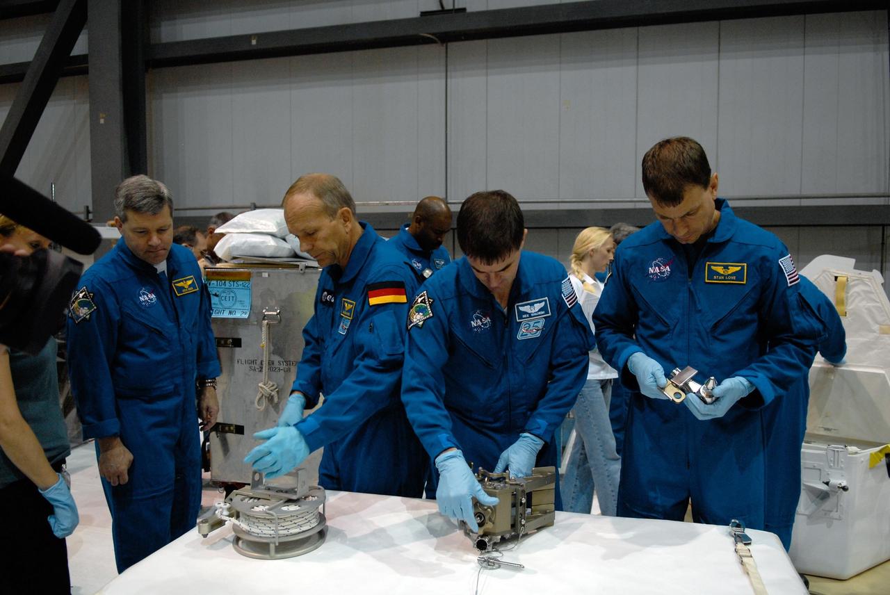 KENNEDY SPACE CENTER, FLA. -- In the Orbiter Processing Facility, STS-122 crew members practice working with equipment for the mission.  From left are Commander Stephen Frick and Mission Specialists Hans Schlegel, Leland Melvin (behind), Rex Walheim and Stanley Love.  Schlegel represents the European Space Agency.  The crew is at Kennedy Space Center to take part in a crew equipment interface test, which includes equipment familiarization.  The mission will carry and install the Columbus Lab,  a multifunctional, pressurized laboratory that will be permanently attached to Node 2 of the space station to carry out experiments in materials science, fluid physics and biosciences, as well as to perform a number of technological applications. It is Europe’s largest contribution to the construction of the International Space Station and will support scientific and technological research in a microgravity environment.  STS-122 is targeted for launch in December.   Photo credit: NASA/Kim Shiflett