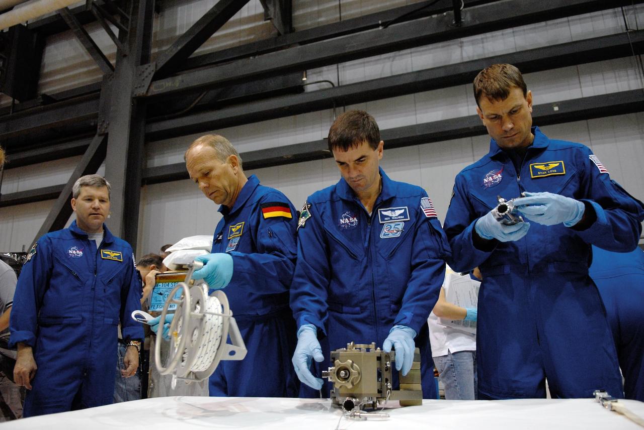 KENNEDY SPACE CENTER, FLA. -- In the Orbiter Processing Facility, STS-122 crew members practice working with equipment for the mission.  From left are Commander Stephen Frick and Mission Specialists Hans Schlegel, Rex Walheim and Stanley Love.  Schlegel represents the European Space Agency. The crew is at Kennedy Space Center to take part in a crew equipment interface test, which includes equipment familiarization.  The mission will carry and install the Columbus Lab,  a multifunctional, pressurized laboratory that will be permanently attached to Node 2 of the space station to carry out experiments in materials science, fluid physics and biosciences, as well as to perform a number of technological applications. It is Europe’s largest contribution to the construction of the International Space Station and will support scientific and technological research in a microgravity environment.  STS-122 is targeted for launch in December.   Photo credit: NASA/Kim Shiflett