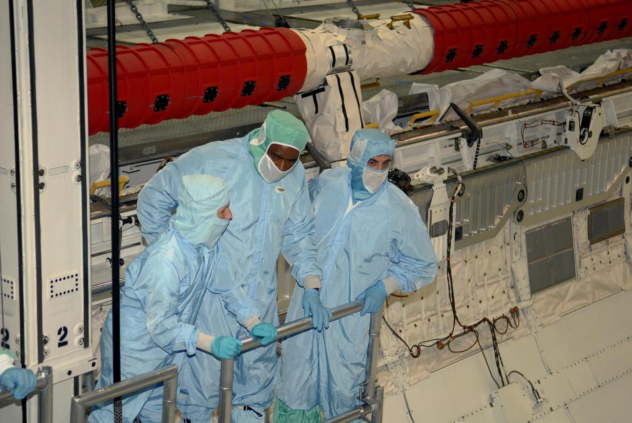 KENNEDY SPACE CENTER, FLA. -- STS-122 crew members take a ride inside space shuttle Atlantis' payload bay to examine components installed there. Seen here are Mission Specialists Leland Melvin (center) and Rex Walheim (right). The crew is at Kennedy Space Center to take part in a crew equipment interface test, which includes equipment familiarization. The mission will carry and install the Columbus Lab, a multifunctional, pressurized laboratory that will be permanently attached to Node 2 of the space station to carry out experiments in materials science, fluid physics and biosciences, as well as to perform a number of technological applications. It is Europe’s largest contribution to the construction of the International Space Station and will support scientific and technological research in a microgravity environment. STS-122 is targeted for launch in December. Photo credit: NASA/Kim Shiflett