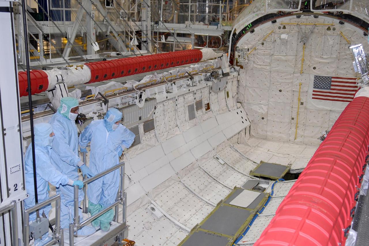 KENNEDY SPACE CENTER, FLA. -- STS-122 crew members take a ride inside space shuttle Atlantis' payload bay to examine components installed there. Seen here are Mission Specialists Leland Melvin (center) and Rex Walheim (right). The crew is at Kennedy Space Center to take part in a crew equipment interface test, which includes equipment familiarization. The mission will carry and install the Columbus Lab, a multifunctional, pressurized laboratory that will be permanently attached to Node 2 of the space station to carry out experiments in materials science, fluid physics and biosciences, as well as to perform a number of technological applications. It is Europe’s largest contribution to the construction of the International Space Station and will support scientific and technological research in a microgravity environment. STS-122 is targeted for launch in December. Photo credit: NASA/Kim Shiflett