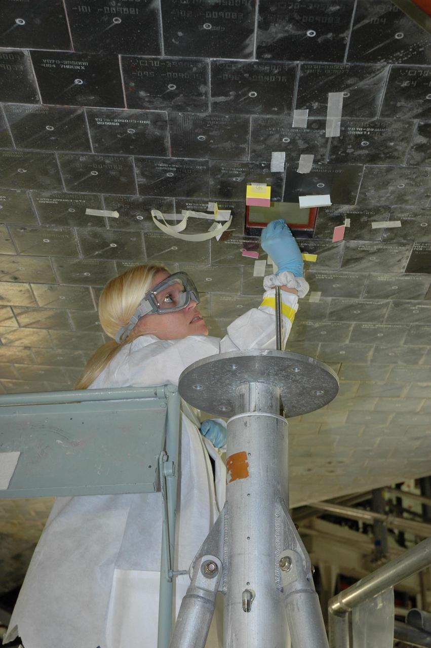 KENNEDY SPACE CENTER, FLA. -- In the Orbiter Processing Facility, a United Space Alliance technician prepares the surface of Atlantis for installation of a thermal protection system tile. Space shuttle Atlantis is targeted for launch on mission STS-122 on Dec. 6. Photo credit: NASA/Jack Pfaller