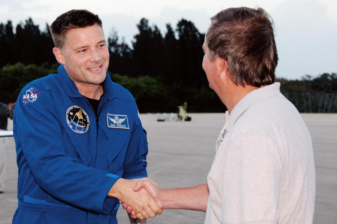 KENNEDY SPACE CENTER, FLA. --  The crew members of mission STS-120 arrive at NASA's Kennedy Space Center Shuttle Landing Facility aboard T-38 jet aircraft to take part in terminal countdown demonstration test activities. Mission Specialist Doug Wheelock, who will be making his first shuttle flight, is welcomed by Shuttle Launch Director Michael Leinbach, at right. The terminal countdown demonstration test provides astronauts and ground crews an opportunity to participate in various simulated countdown activities, including equipment familiarization and emergency training. The STS-120 mission will deliver the U.S. Node 2 module, named Harmony, aboard space shuttle Discovery to the International Space Station.  Launch of Discovery on mission STS-120 is targeted for Oct. 23 at 11:38 a.m. EDT on a 14-day mission to the International Space Station.  Photo credit: NASA/Kim Shiflett