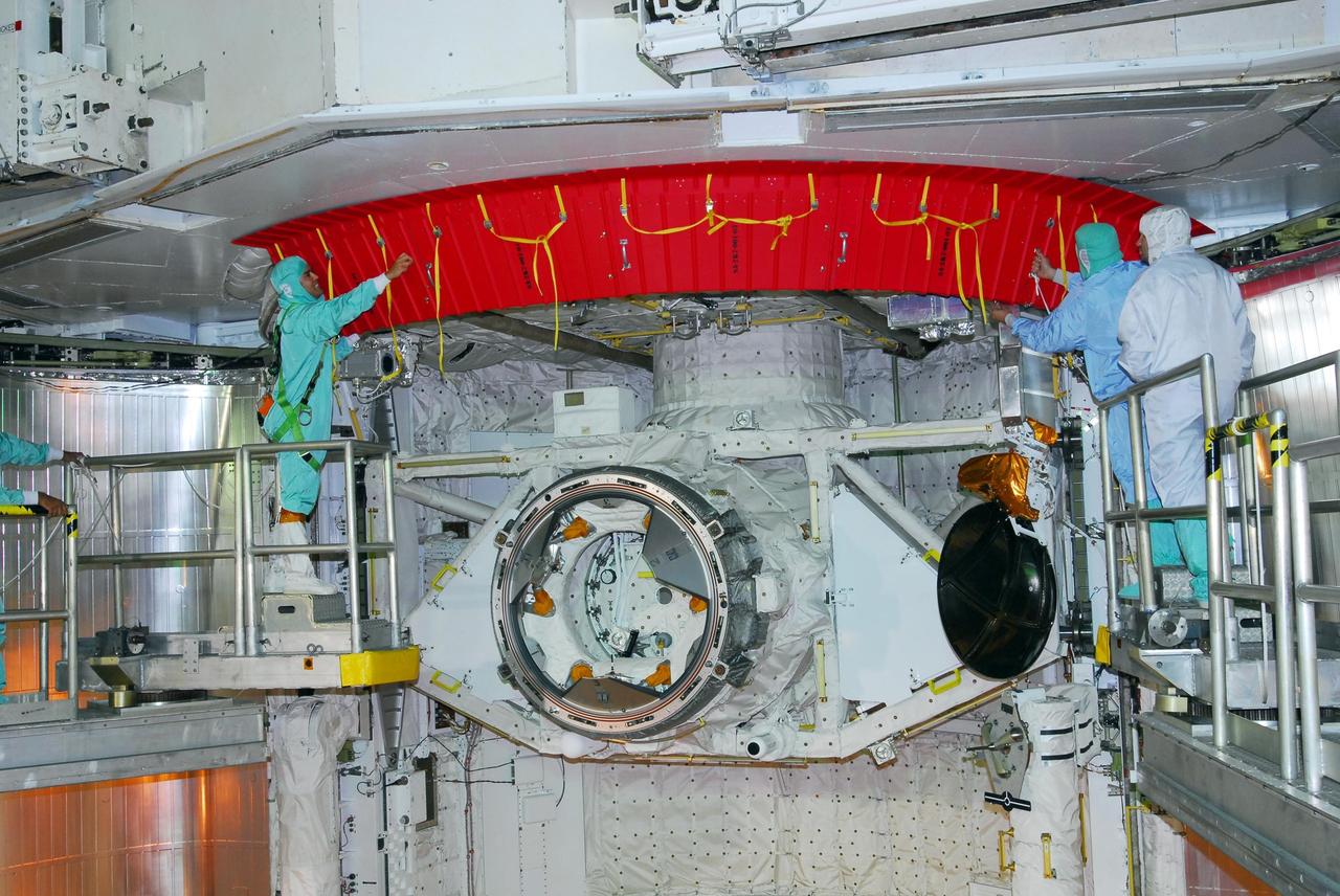 KENNEDY SPACE CENTER, FLA. -- On Launch Pad 39A, workers are removing the rain gutters from space shuttle Discovery's payload bay. The gutters prevent leaks into the bay from rain while the shuttle is on the pad. Beneath is the orbital docking system. Mission STS-120 will bring the Harmony module that will provide attachment points for European and Japanese laboratory modules to the International Space Station. Launch of Discovery is targeted for Oct. 23. Photo credit: NASA/George Shelton