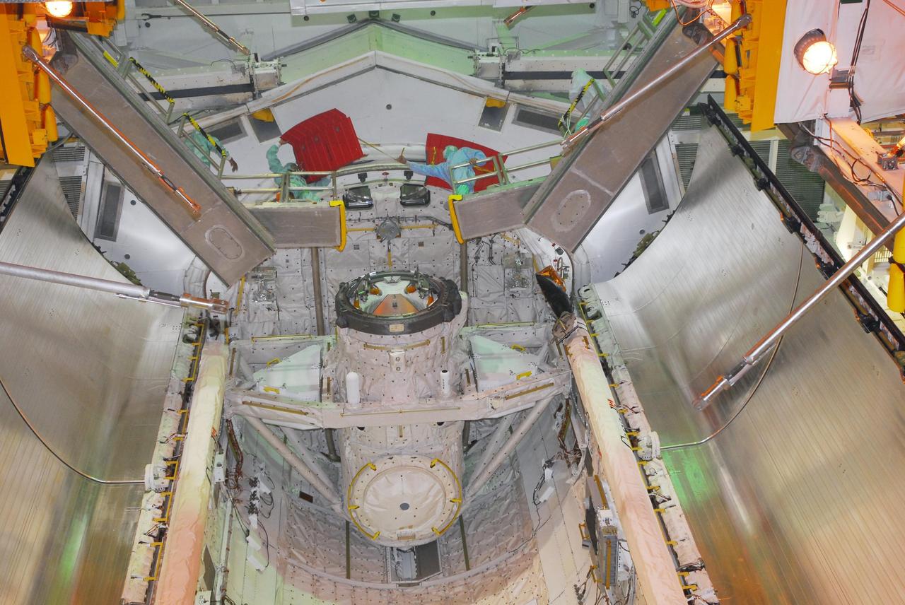 KENNEDY SPACE CENTER, FLA. -- On Launch Pad 39A, workers remove the rain gutters from space shuttle Discovery's payload bay. The gutters prevent leaks into the bay from rain while the shuttle is on the pad. Beneath is the orbital docking system. Mission STS-120 will bring the Harmony module that will provide attachment points for European and Japanese laboratory modules to the International Space Station. Launch of Discovery is targeted for Oct. 23. Photo credit: NASA/George Shelton