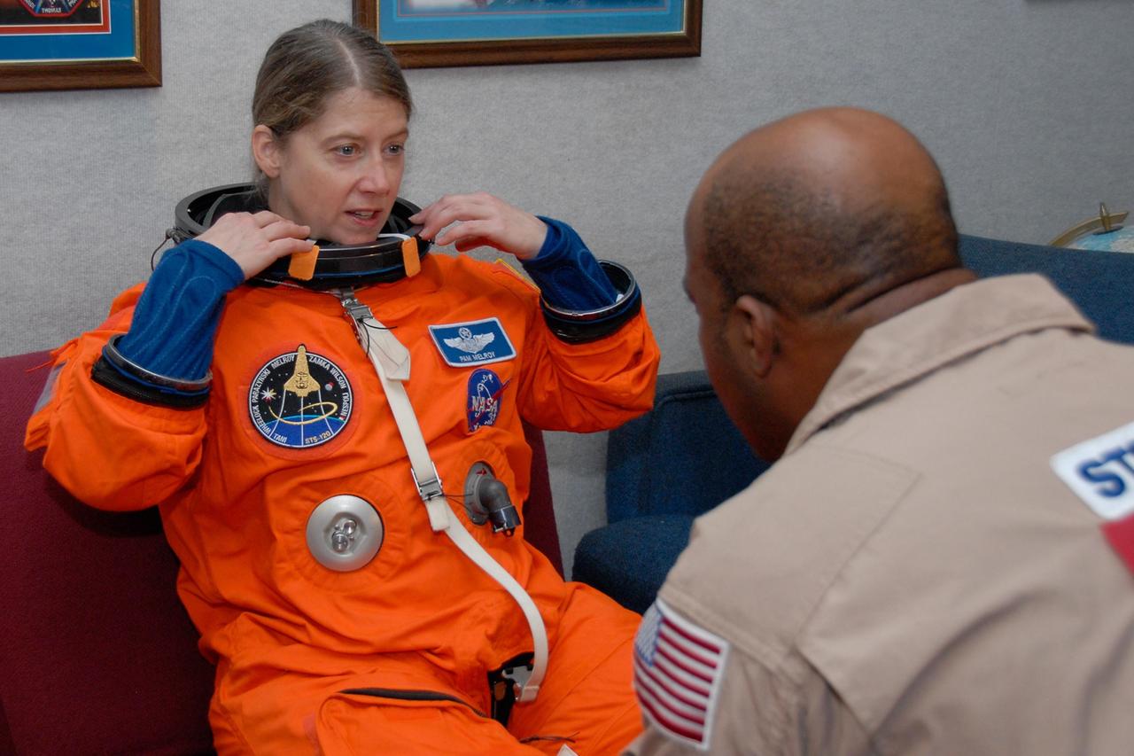 KENNEDY SPACE CENTER, FLA. --  STS-120 Commander Pamela Melroy dons her launch and entry suit.  She will be practicing landing on NASA's Shuttle Landing Facility runway in the shuttle training aircraft, or STA.  A modified Grumman American Aviation-built Gulf Stream II jet, the STA simulates an orbiter's cockpit, motion and visual cues and handling qualities. In flight, the STA duplicates the orbiter's atmospheric descent trajectory from approximately 35,000 feet altitude to landing on a runway.  Melroy and other crew members are at Kennedy Space Center to take part in the terminal countdown demonstration test, which also includes a simulated launch countdown. Mission STS-120 is targeted for Oct. 23.  Photo credit: NASA/Kim Shiflett