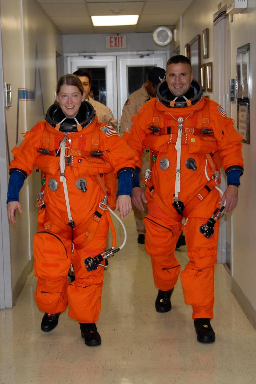 KENNEDY SPACE CENTER, FLA. --  STS-120 Commander Pamela Melroy and Pilot George Zamka are suited in their orange launch and entry suits and on their way to NASA's Shuttle Landing Facility to practice landing in the shuttle training aircraft, or STA.  A modified Grumman American Aviation-built Gulf Stream II jet, the STA simulates an orbiter's cockpit, motion and visual cues and handling qualities. In flight, the STA duplicates the orbiter's atmospheric descent trajectory from approximately 35,000 feet altitude to landing on a runway.  Melroy and other crew members are at Kennedy Space Center to take part in the terminal countdown demonstration test, which also includes a simulated launch countdown. Mission STS-120 is targeted for Oct. 23.  Photo credit: NASA/Kim Shiflett