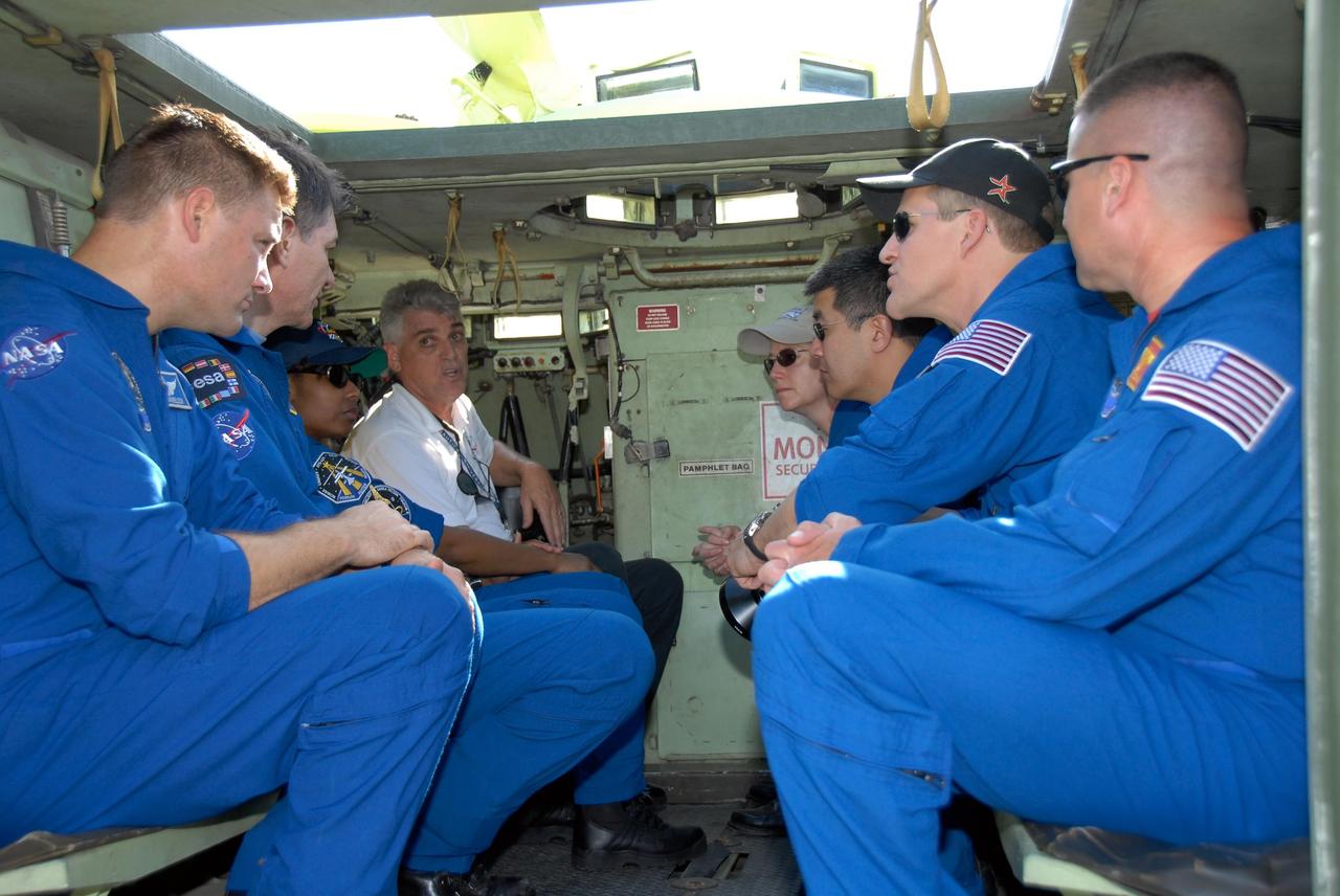 KENNEDY SPACE CENTER, FLA. --  STS-120 crew members listen to instructions about the use of the M-113 armored personnel carrier for emergency exit procedures from Launch Pad 39A.  From the front, on the left, are Mission Specialists Doug Wheelock, Paolo Nespoli and Stephanie Wilson; at right are Pilot George Zamka, Mission Specialists Scott Parazynski and Daniel Tani, and Commander Pamela Melroy.  Nespoli represents the European Space Agency. The training is part of terminal countdown demonstration test, or TCDT, activities the crew is undertaking at NASA's Kennedy Space Center. The TCDT also includes equipment familiarization and a simulated launch countdown. Mission STS-120, which will carry the Italian-built U.S. Node 2 to the International Space Station, is targeted for launch on Oct. 23.  Photo credit: NASA/Kim Shiflett