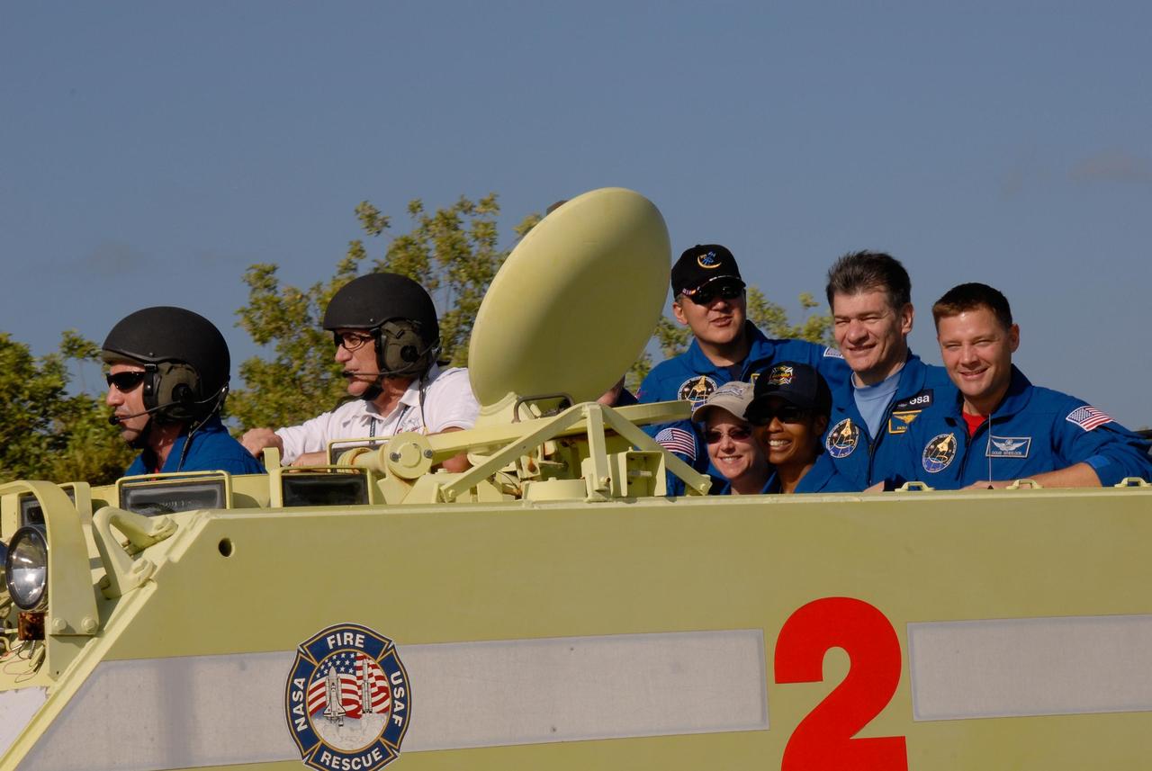 KENNEDY SPACE CENTER, FLA. --  STS-120 Pilot George Zamka practices driving the M-113 armored personnel carrier, part of emergency exit procedures from Launch Pad 39A.   Alongside is the trainer. In the rear of the M-113 are Mission Specialists Daniel Tani, Commander Pamela Melroy and Mission Specialists Stephanie Wilson, Paolo Nespoli and Doug Wheelock.  Nespoli represents the European Space Agency.  The training is part of terminal countdown demonstration test, or TCDT, activities the crew is undertaking at NASA's Kennedy Space Center. The TCDT also includes equipment familiarization and a simulated launch countdown. Mission STS-120, which will carry the Italian-built U.S. Node 2 to the International Space Station, is targeted for launch on Oct. 23.  Photo credit: NASA/Kim Shiflett