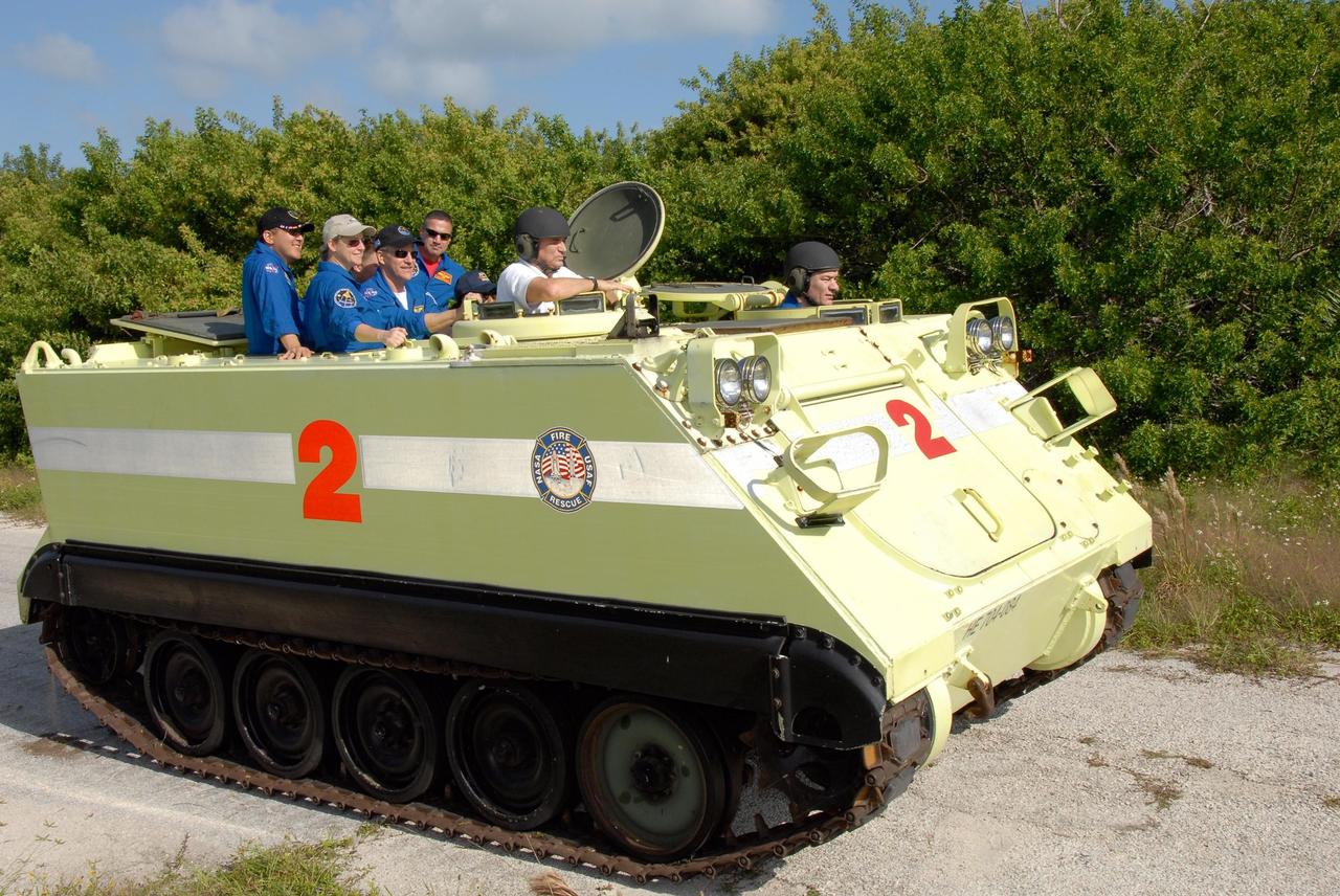 KENNEDY SPACE CENTER, FLA. --  STS-120 Mission Specialist Paolo Nespoli, who represents the European Space Agency, practices driving the M-113 armored personnel carrier, which is part of emergency exit procedures from Launch Pad 39A.  Also in front is the trainer.  Passenger crew members in the rear are (from left) Mission Specialists Daniel Tani, Commander Pamela Melroy, Mission Specialist Scott Parazynski and Pilot George Zamka.  The training is part of terminal countdown demonstration test, or TCDT, activities the crew is undertaking at NASA's Kennedy Space Center. The TCDT also includes equipment familiarization and a simulated launch countdown. Mission STS-120, which will carry the Italian-built U.S. Node 2 to the International Space Station, is targeted for launch on Oct. 23.  Photo credit: NASA/Kim Shiflett
