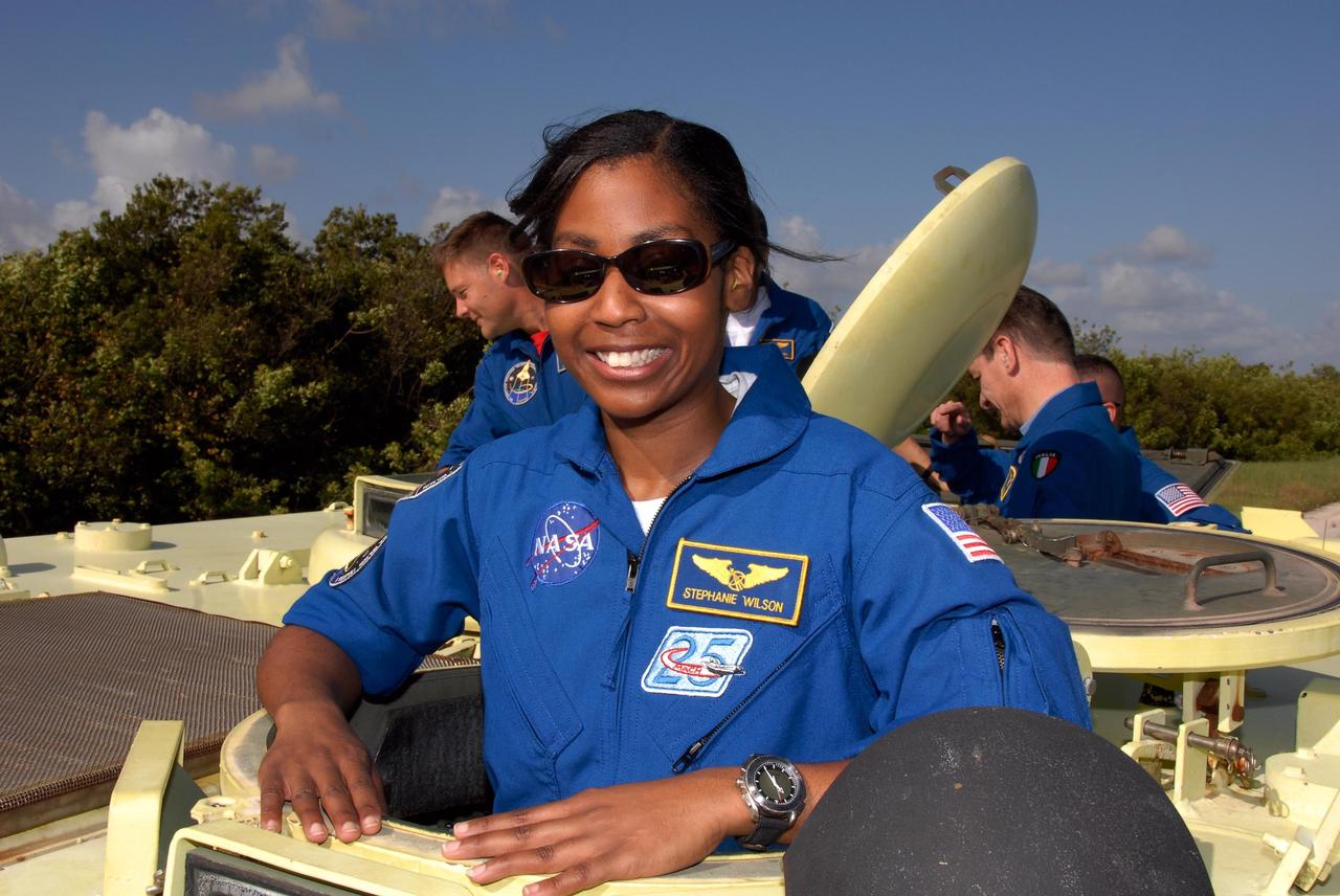 KENNEDY SPACE CENTER, FLA. --  STS-120 Mission Specialist Stephanie Wilson is ready for her turn at driving the M-113 armored personnel carrier. The M-113 is part of emergency exit procedures from Launch Pad 39A.  Behind her are Mission Specialists Doug Wheelock, at left) and Paolo Nespoli, who represents the European Space Agency.  The training is part of terminal countdown demonstration test, or TCDT, activities the crew is undertaking at NASA's Kennedy Space Center. The TCDT also includes equipment familiarization and a simulated launch countdown. Mission STS-120, which will carry the Italian-built U.S. Node 2 to the International Space Station, is targeted for launch on Oct. 23.  Photo credit: NASA/Kim Shiflett