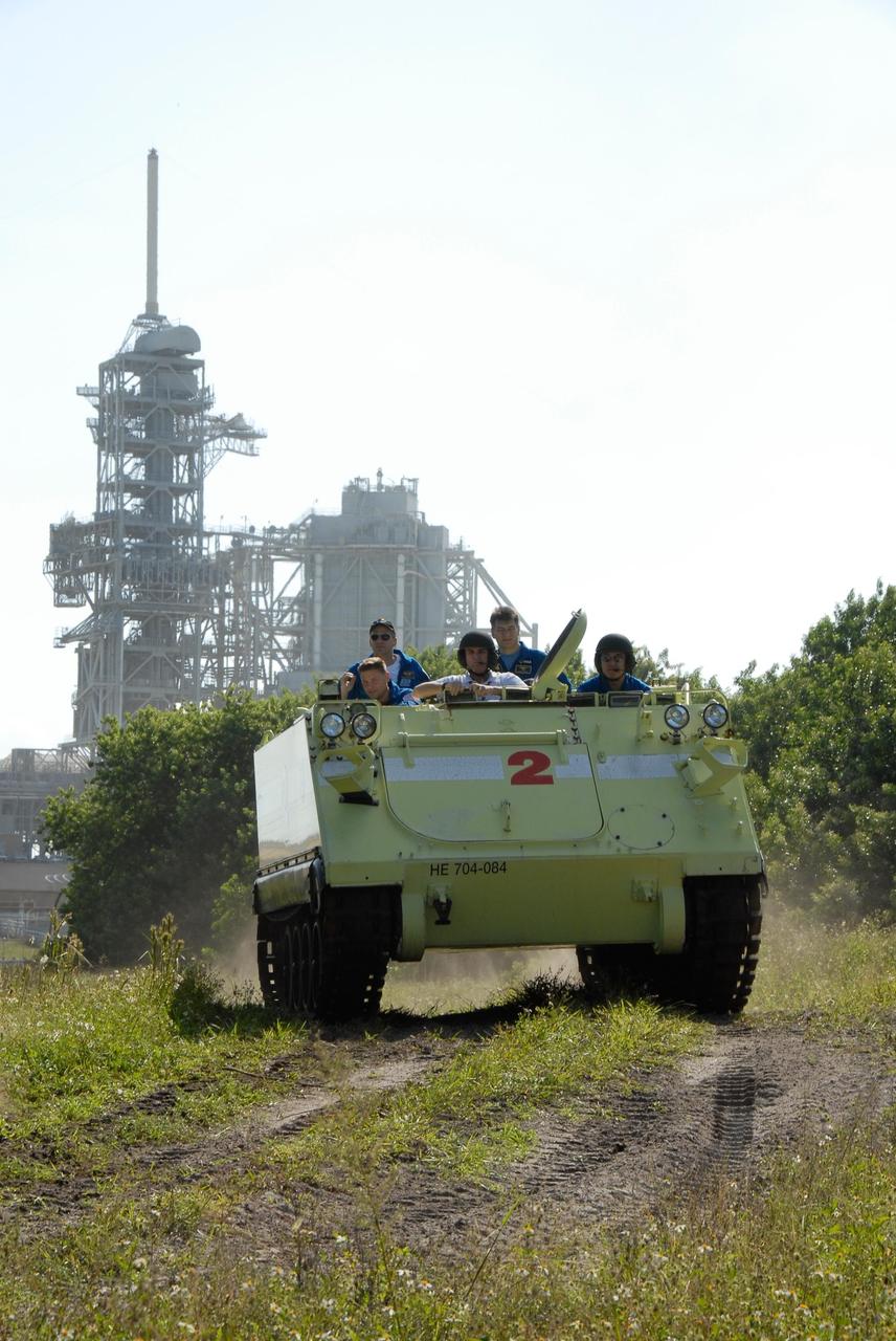 KENNEDY SPACE CENTER, FLA. --  Driven by Mission Specialist Daniel Tani, the M-113 armored personnel carrier moves through the underbrush near Launch Pad 39A.  The M-113 is part of emergency exit procedures from Launch Pad 39A.  Also in front is the trainer.  In the rear are Mission Specialists Doug Wheelock, Scott Parazynski and Paolo Nespoli, who represents the European Space Agency. The training is part of terminal countdown demonstration test, or TCDT, activities the crew is undertaking at NASA's Kennedy Space Center. The TCDT also includes equipment familiarization and a simulated launch countdown. Mission STS-120, which will carry the Italian-built U.S. Node 2 to the International Space Station, is targeted for launch on Oct. 23.  Photo credit: NASA/Kim Shiflett