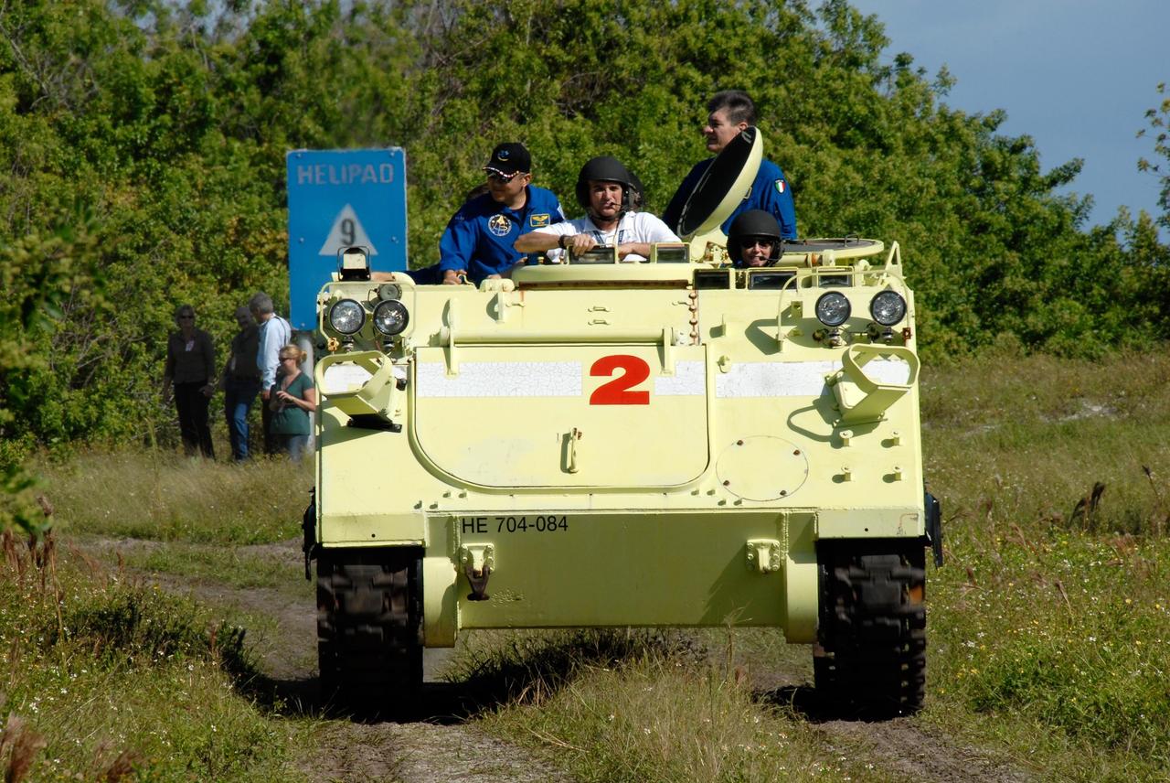 KENNEDY SPACE CENTER, FLA. --  STS-120 Commander Pamela Melroy drives the M-113 armored personnel carrier near Launch Pad 39A as part of emergency exit procedures.  Beside her in front  is the trainer.  In the rear are Mission Specialists Daniel Tani and Paolo Nespoli, who represents the European Space Agency. The training is part of terminal countdown demonstration test, or TCDT, activities the crew is undertaking at NASA's Kennedy Space Center. The TCDT also includes equipment familiarization and a simulated launch countdown. Mission STS-120, which will carry the Italian-built U.S. Node 2 to the International Space Station, is targeted for launch on Oct. 23.  Photo credit: NASA/Kim Shiflett