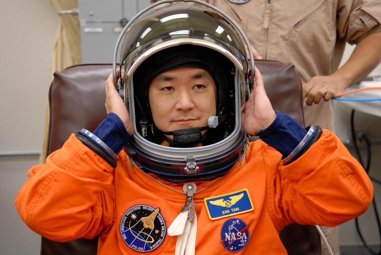 KENNEDY SPACE CENTER, FLA. -- STS-120 Mission Specialist Daniel Tani tries on his helmet with his launch and entry suit, preparing for launch. The fitting is part of terminal countdown demonstration test, or TCDT, activities the crew is undertaking at NASA's Kennedy Space Center. The TCDT also includes emergency egress procedures, equipment familiarization and a simulated launch countdown. Mission STS-120, which will carry the Italian-built U.S. Node 2 to the International Space Station, is targeted for launch on Oct. 23. Photo credit: NASA/Kim Shiflett