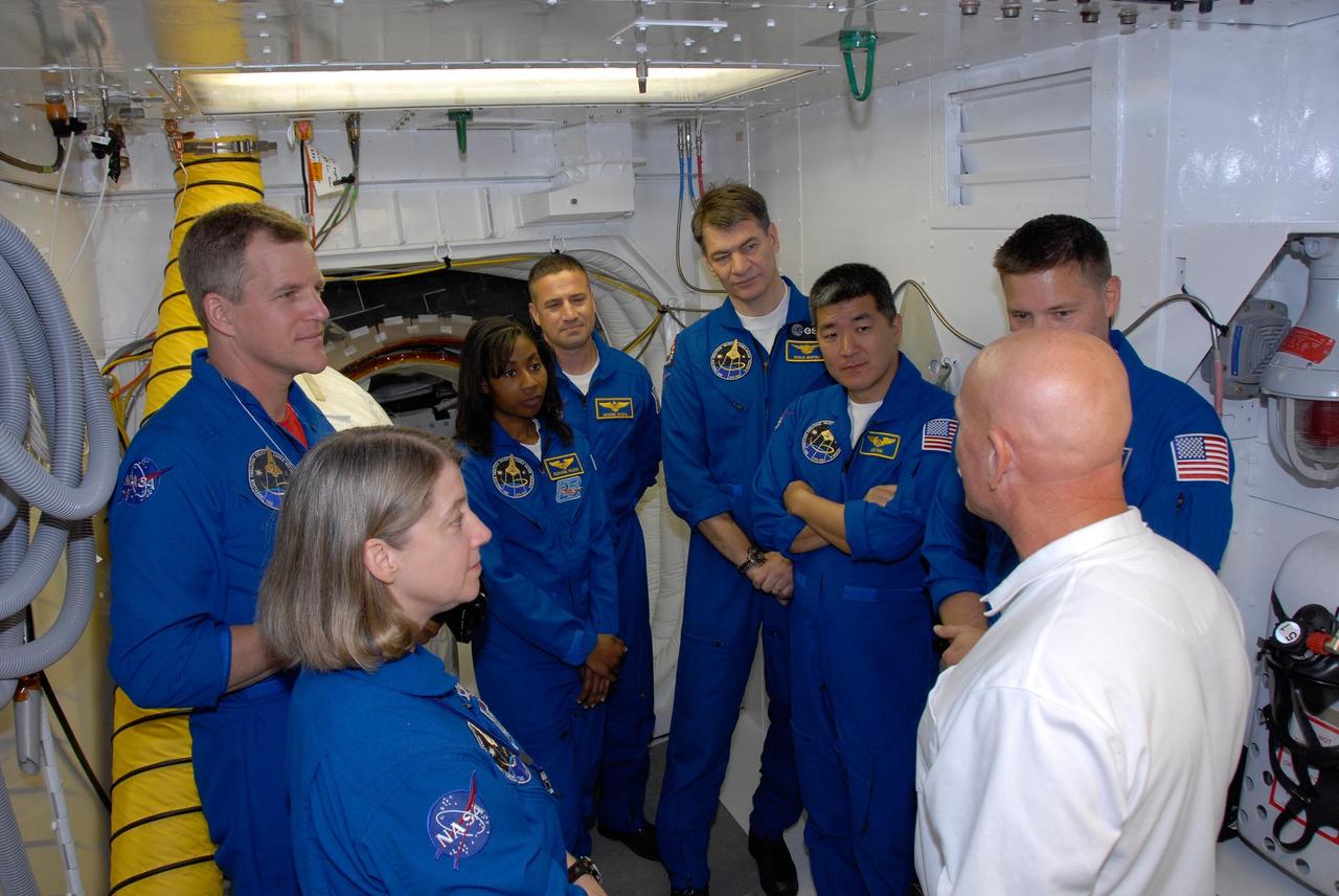 KENNEDY SPACE CENTER, FLA. -- The STS-120 crew is at NASA's Kennedy Space Center for the pre-launch terminal countdown demonstration test, or TCDT. Gathered in the white room on Launch Pad 39A, the crew gets instructions on emergency egress from the space shuttle. Clockwise from lower left are Commander Pamela Melroy, Mission Specialists Scott Parazynski and Stephanie Wilson, Pilot George Zamka, and Mission Specialists Paolo Nespoli, Daniel Tani and Doug Wheelock. Nespoli represents the European Space Agency. Tani will remain aboard the International Space Station and return with the STS-122 crew, targeted to launch Dec. 6. The TCDT provides astronauts and ground crews an opportunity to participate in various simulated countdown activities, including equipment familiarization and emergency training. The STS-120 mission will deliver the U.S. Node 2 module, named Harmony, aboard space shuttle Discovery to the International Space Station. Launch of Discovery on mission STS-120 is targeted for Oct. 23 at 11:38 a.m. EDT on a 14-day mission. Photo credit: NASA/Kim Shiflett
