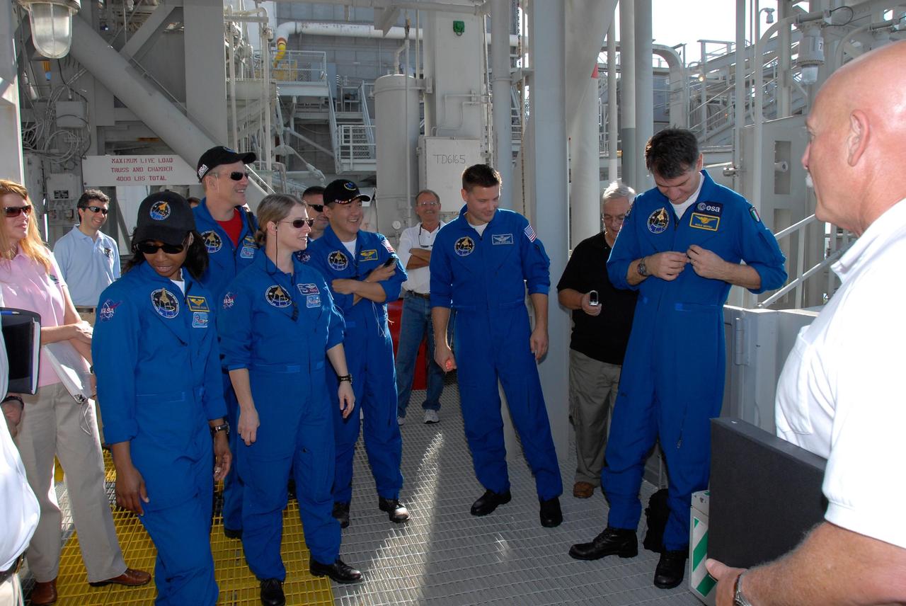 KENNEDY SPACE CENTER, FLA. -- The STS-120 crew is at NASA's Kennedy Space Center for the pre-launch terminal countdown demonstration test, or TCDT. Here, the crew gets instructions about emergency egress from the fixed service structure. From left are Mission Specialists Stephanie Wilson and Scott Parazynski, Commander Pamela Melroy, Pilot George Zamka, and Mission Specialists Daniel Tani, Doug Wheelock and Paolo Nespoli, who represents the European Space Agency. After the mission, Tani will remain aboard the International Space Station and return with the STS-122 crew, targeted to launch Dec. 6. The TCDT provides astronauts and ground crews an opportunity to participate in various simulated countdown activities, including equipment familiarization and emergency training. The STS-120 mission will deliver the U.S. Node 2 module, named Harmony, aboard space shuttle Discovery to the International Space Station. Launch of Discovery on mission STS-120 is targeted for Oct. 23 at 11:38 a.m. EDT on a 14-day mission. Photo credit: NASA/Kim Shiflett