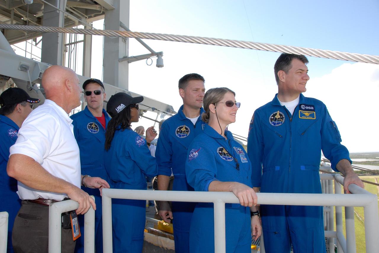 KENNEDY SPACE CENTER, FLA. -- The STS-120 crew is at NASA's Kennedy Space Center for the pre-launch terminal countdown demonstration test, or TCDT. During emergency egress training, crew members look at the distant landing site for the slidewire baskets that can carry the crew safely away from the shuttle. From left are Mission Specialists Daniel Tani, Scott Parazynski, Stephanie Wilson and Doug Wheelock, Commander Pamela Melroy and Mission Specialist Paolo Nespoli, who represents the European Space Agency. After the mission, Tani will remain aboard the International Space Station and return with the STS-122 crew, targeted to launch Dec. 6. The TCDT provides astronauts and ground crews an opportunity to participate in various simulated countdown activities, including equipment familiarization and emergency training. The STS-120 mission will deliver the U.S. Node 2 module, named Harmony, aboard space shuttle Discovery to the International Space Station. Launch of Discovery on mission STS-120 is targeted for Oct. 23 at 11:38 a.m. EDT on a 14-day mission. Photo credit: NASA/Kim Shiflett
