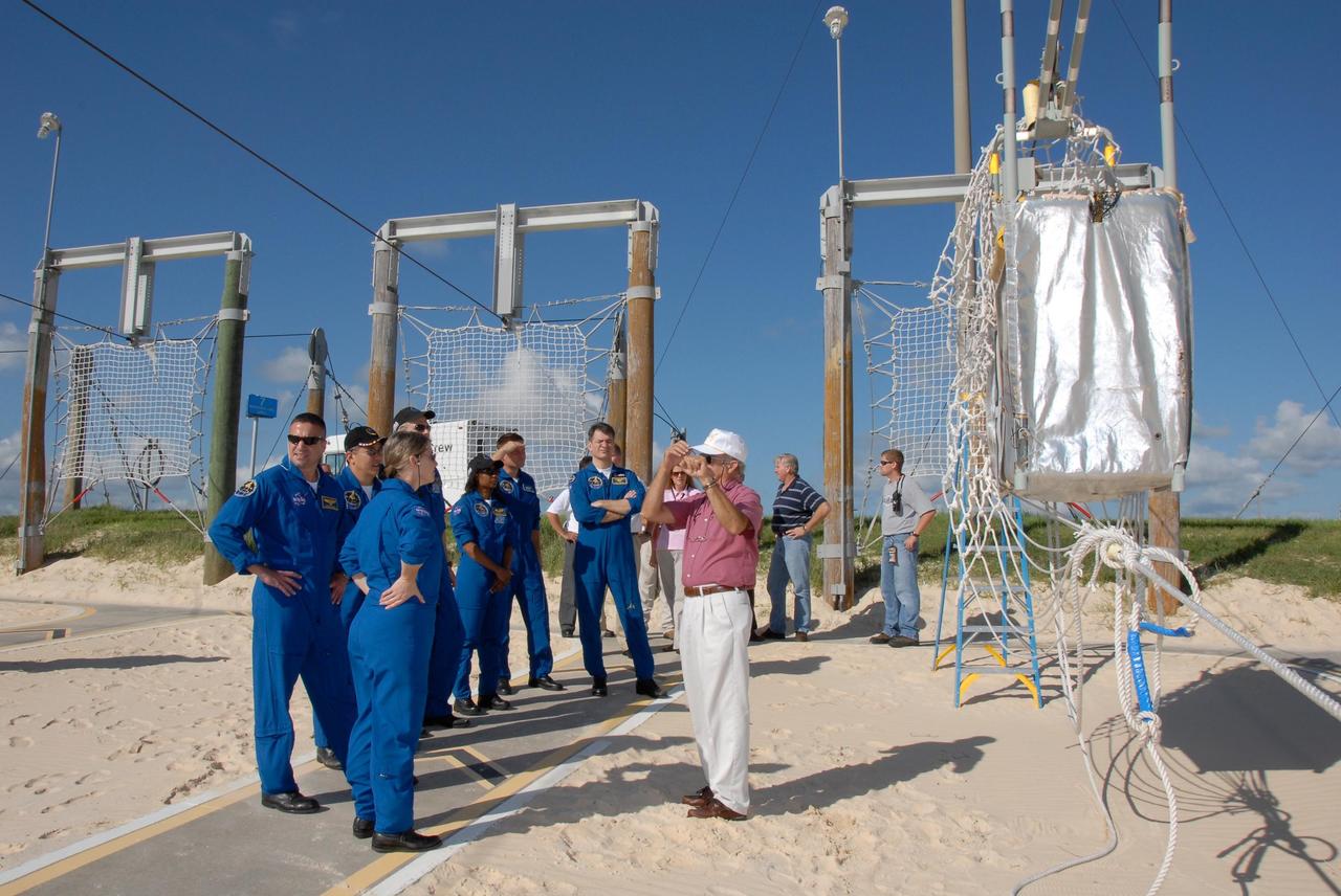 KENNEDY SPACE CENTER, FLA. -- The STS-120 crew is at NASA's Kennedy Space Center for the pre-launch terminal countdown demonstration test, or TCDT.  During emergency egress training, the crew gets instructions about what to do when the slidewire baskets (at right) reach the landing site.  In the foreground is Commander Pamela Melroy; lined up behind her are Pilot George Zamka and Mission Specialists Daniel Tani, Scott Parazynski, Stephanie Wilson, Doug Wheelock and Paolo Nespoli, who represents the European Space Agency.  After the mission, Tani will remain aboard the International Space Station and return with the STS-122 crew, targeted to launch Dec. 6.  The TCDT provides astronauts and ground crews an opportunity to participate in various simulated countdown activities, including equipment familiarization and emergency training. The STS-120 mission will deliver the U.S. Node 2 module, named Harmony, aboard space shuttle Discovery to the International Space Station.  Launch of Discovery on mission STS-120 is targeted for Oct. 23 at 11:38 a.m. EDT on a 14-day mission.  Photo credit: NASA/Kim Shiflett