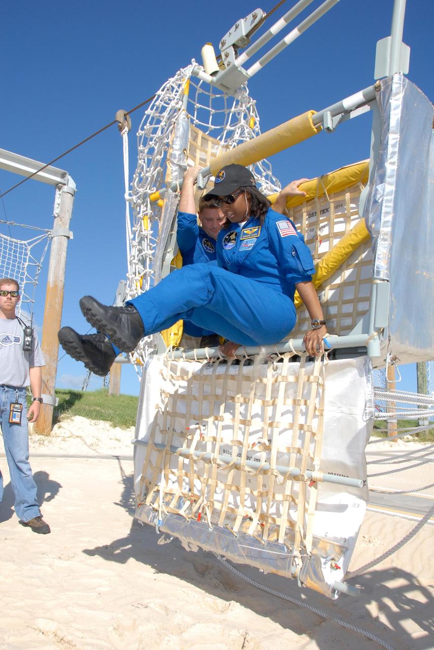 KENNEDY SPACE CENTER, FLA. -- During emergency egress training as part of the pre-launch terminal countdown demonstration test, or TCDT, STS-120 crew members practice getting out of the slidewire basket at the landing site. Jumping out is Mission Specialist Stephanie Wilson. Waiting his turn behind her is Mission Specialist Doug Wheelock. The TCDT provides astronauts and ground crews an opportunity to participate in various simulated countdown activities, including equipment familiarization and emergency training. The STS-120 mission will deliver the U.S. Node 2 module, named Harmony, aboard space shuttle Discovery to the International Space Station. Launch of Discovery on mission STS-120 is targeted for Oct. 23 at 11:38 a.m. EDT on a 14-day mission. Photo credit: NASA/Kim Shiflett