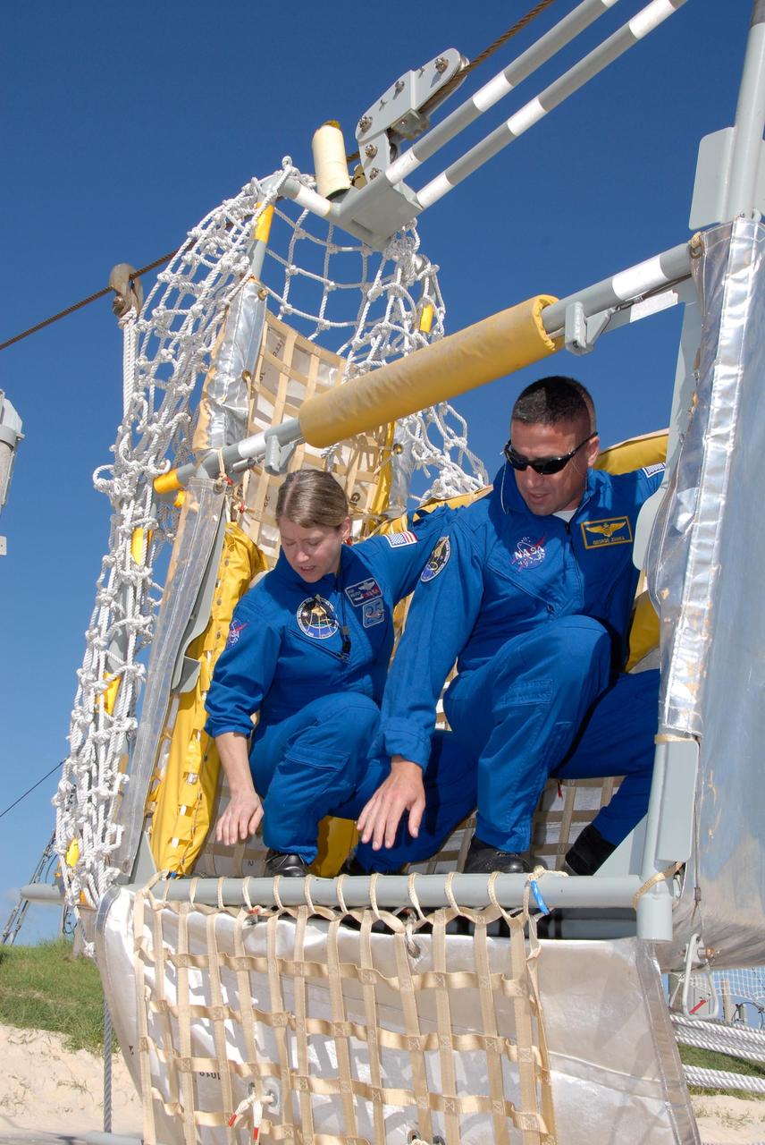 KENNEDY SPACE CENTER, FLA. -- During emergency egress training as part of the pre-launch terminal countdown demonstration test, or TCDT, STS-120 crew members learn how to get out of the slidewire basket at the landing site. In the basket are Commander Pamela Melroy and Pilot George Zamka. The TCDT provides astronauts and ground crews an opportunity to participate in various simulated countdown activities, including equipment familiarization and emergency training. The STS-120 mission will deliver the U.S. Node 2 module, named Harmony, aboard space shuttle Discovery to the International Space Station. Launch of Discovery on mission STS-120 is targeted for Oct. 23 at 11:38 a.m. EDT on a 14-day mission. Photo credit: NASA/Kim Shiflett