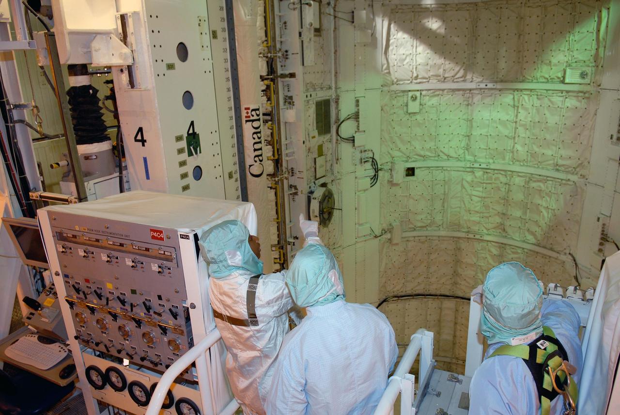 KENNEDY SPACE CENTER, FLA. -- In space shuttle Discovery's payload bay, STS-120 crew members get a close look at the equipment and payloads. Seen here, from left, are Mission Specialists Stephanie Wilson, Daniel Tani and Scott Parazynski. After the mission, Tani will remain aboard the International Space Station and return with the STS-122 crew, targeted to launch Dec. 6. The TCDT provides astronauts and ground crews an opportunity to participate in various simulated countdown activities, including equipment familiarization and emergency training. The STS-120 mission will deliver the U.S. Node 2 module, named Harmony, aboard space shuttle Discovery to the International Space Station. Launch of Discovery on mission STS-120 is targeted for Oct. 23 at 11:38 a.m. EDT on a 14-day mission. Photo credit: NASA/Kim Shiflett